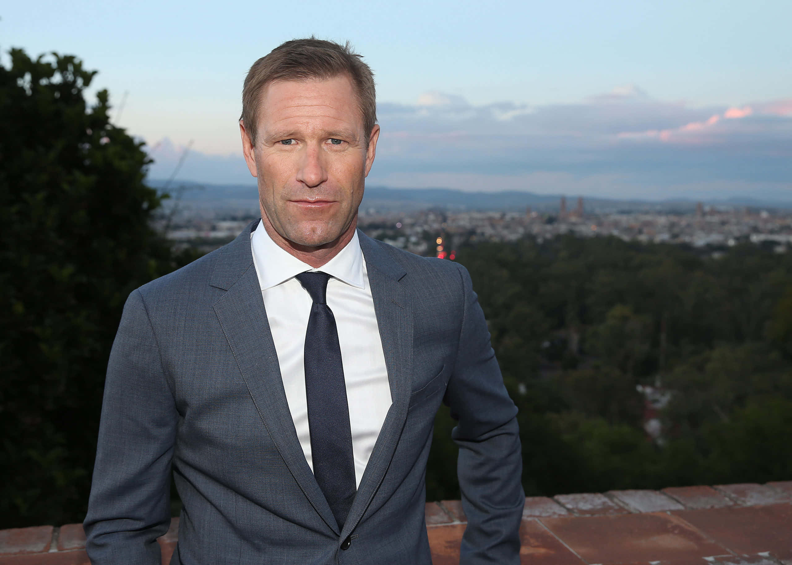 Aaron Eckhart con cielo azul y ciudad Fondos de pantalla