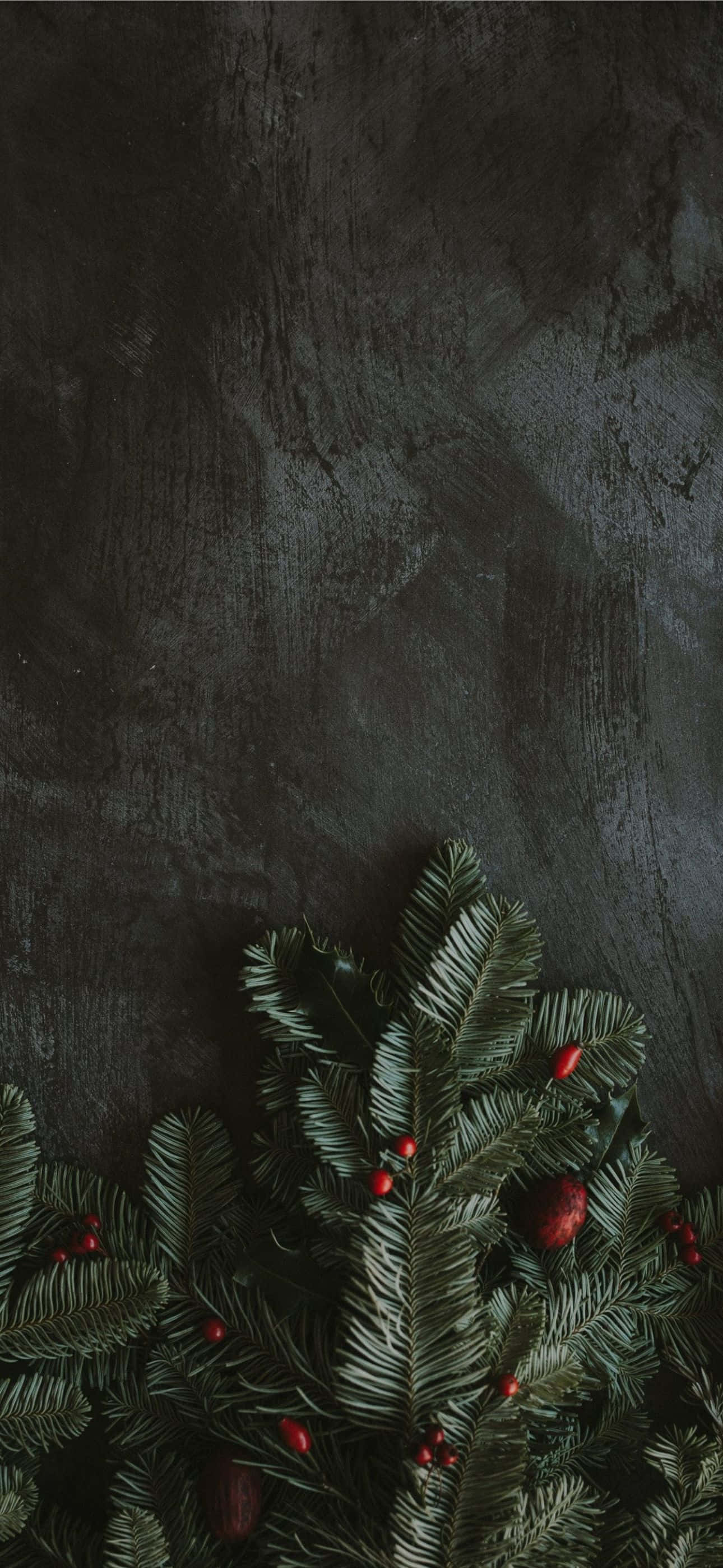 Adorno navideño rojo sobre un iPhone dorado Fondos de pantalla