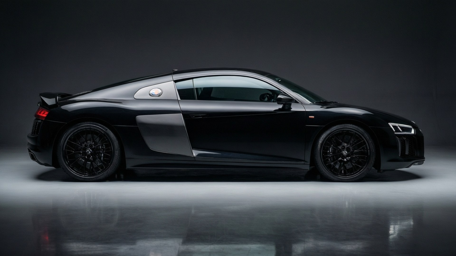 Un Audi R8 negro capturado en un entorno de estudio limpio, resaltando su diseño elegante.