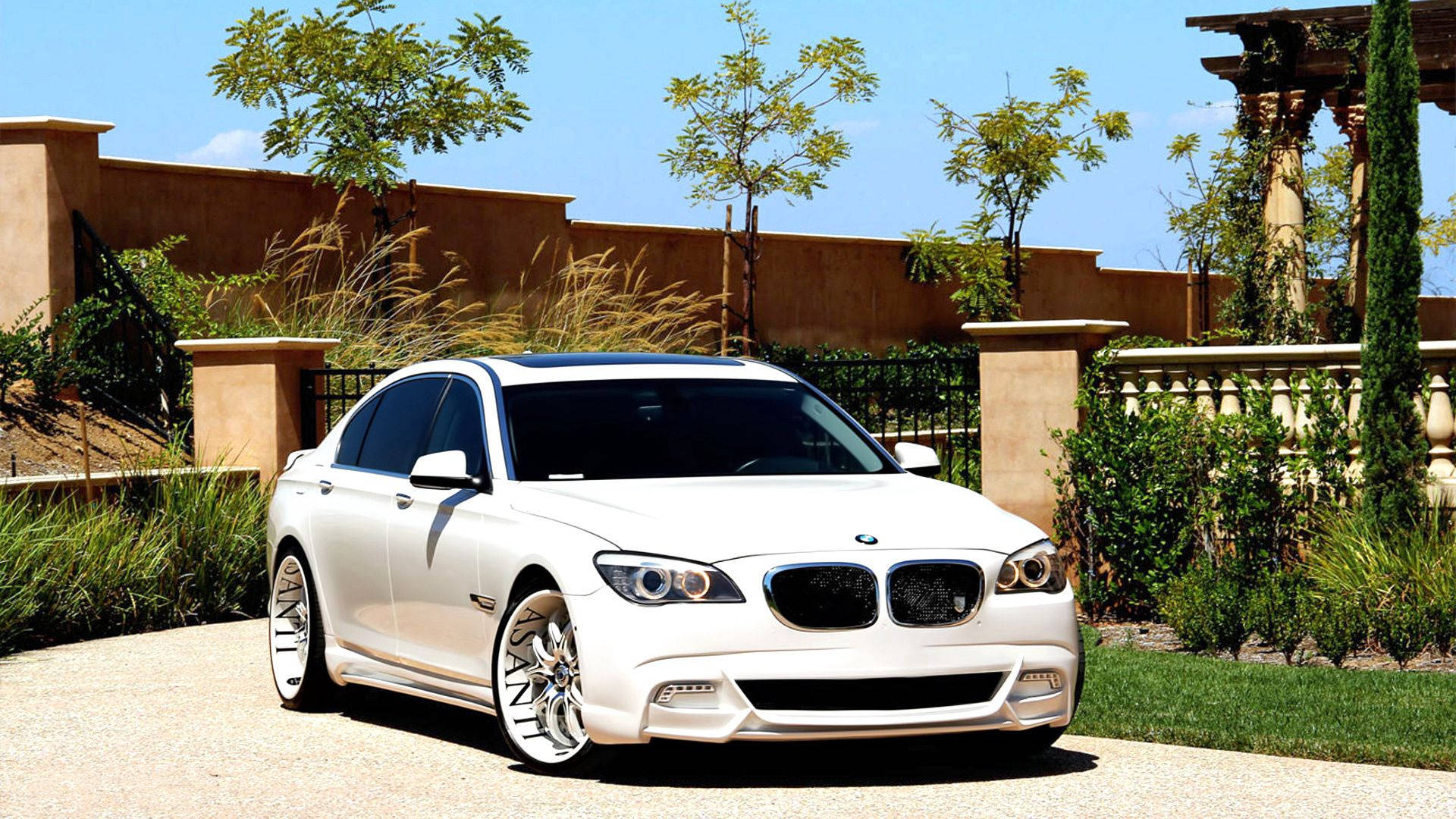 Fondo de pantalla de un BMW Serie 7 F01 blanco con tuning Asanti en la entrada