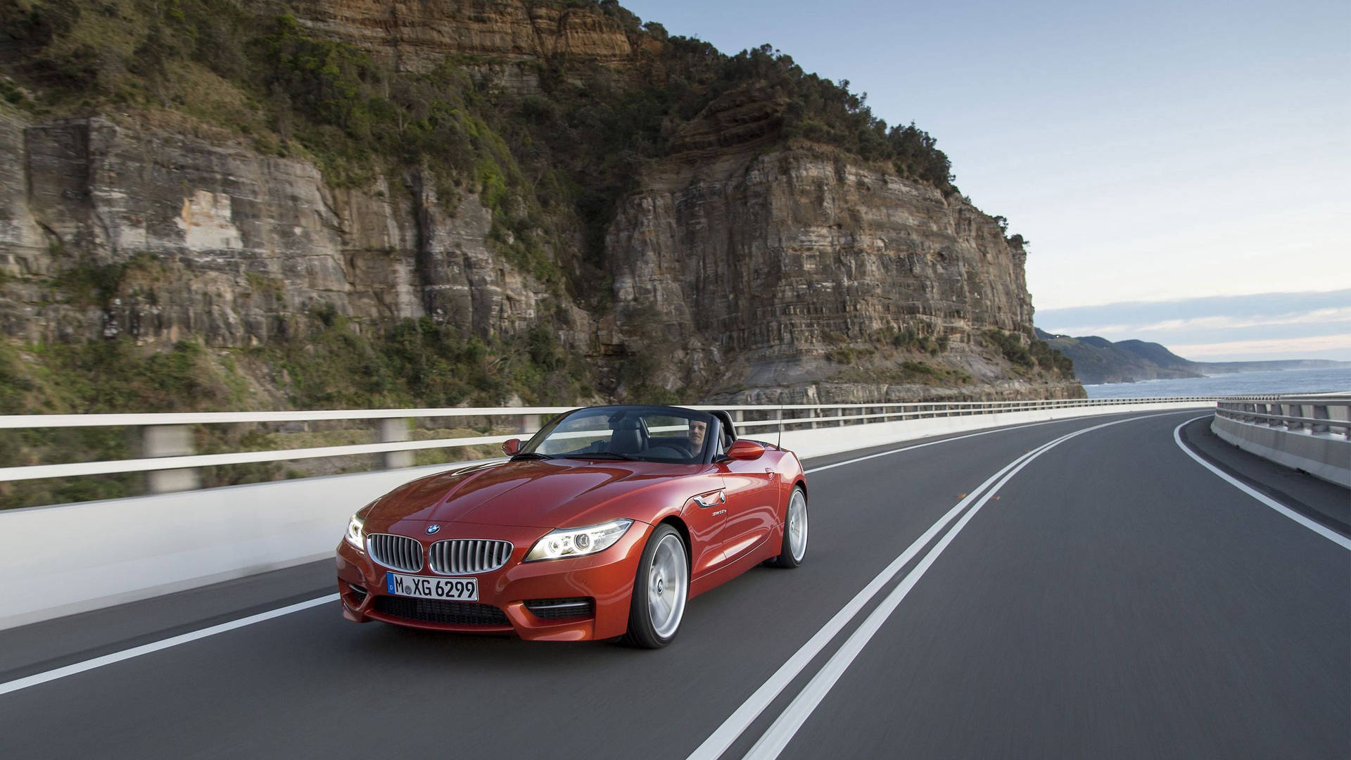 Fondo de pantalla del BMW Z4 naranja en la carretera junto a la montaña