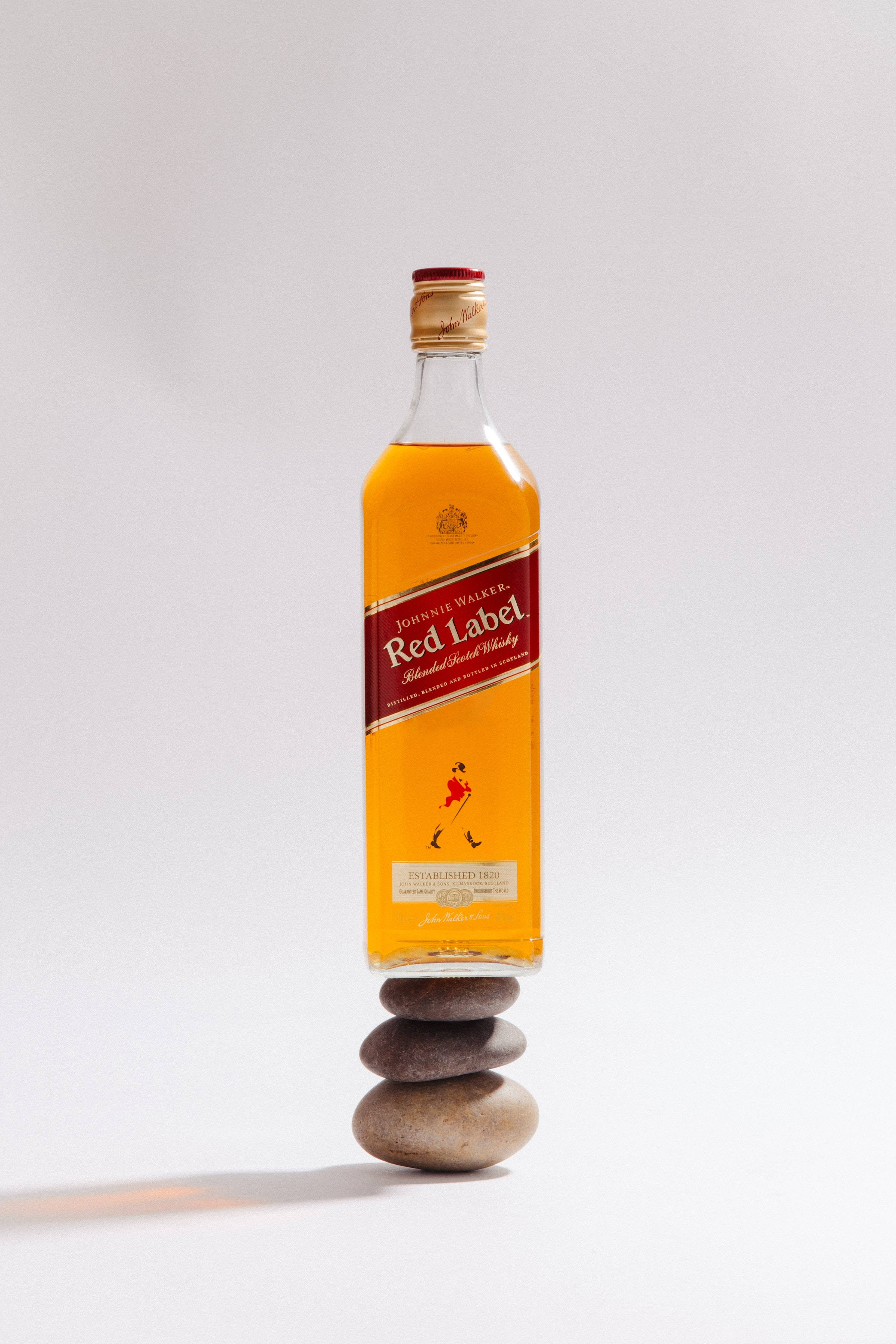Botella de whiskey Red Label sobre pila de piedras Fondos de pantalla