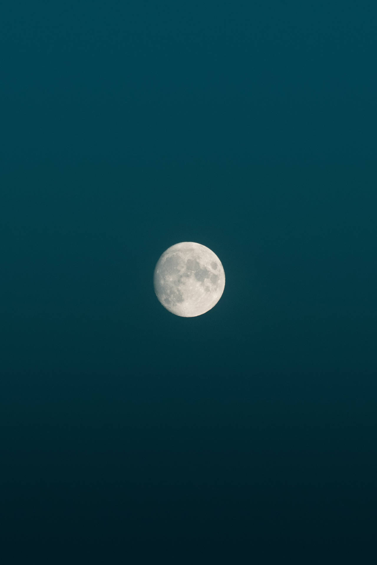 Brillo de la luna llena durante la medianoche en un cielo azul de estética minimalista. Luna y su superficie visible.