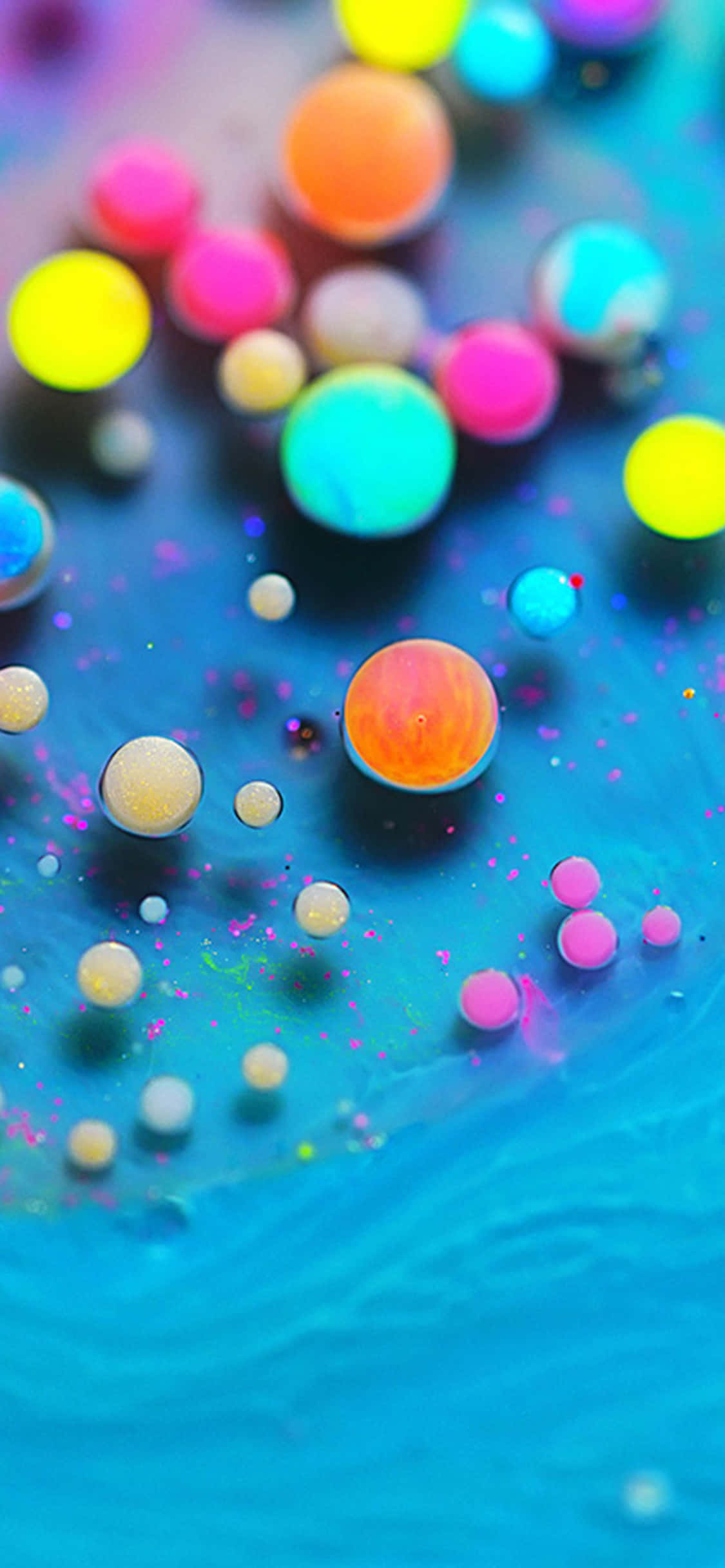 burbujas de colores flotando en un líquido azul Fondos de pantalla