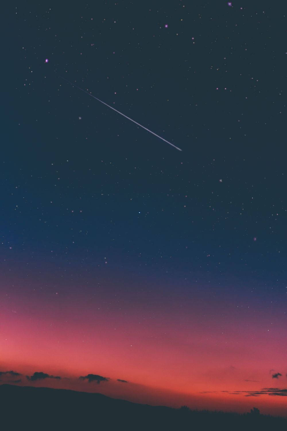 Cielo nocturno rosa oscuro con estrellas fugaces y cielos estéticos. Un cielo dramático y mágico con estrellas y cielo rosa y azul.
