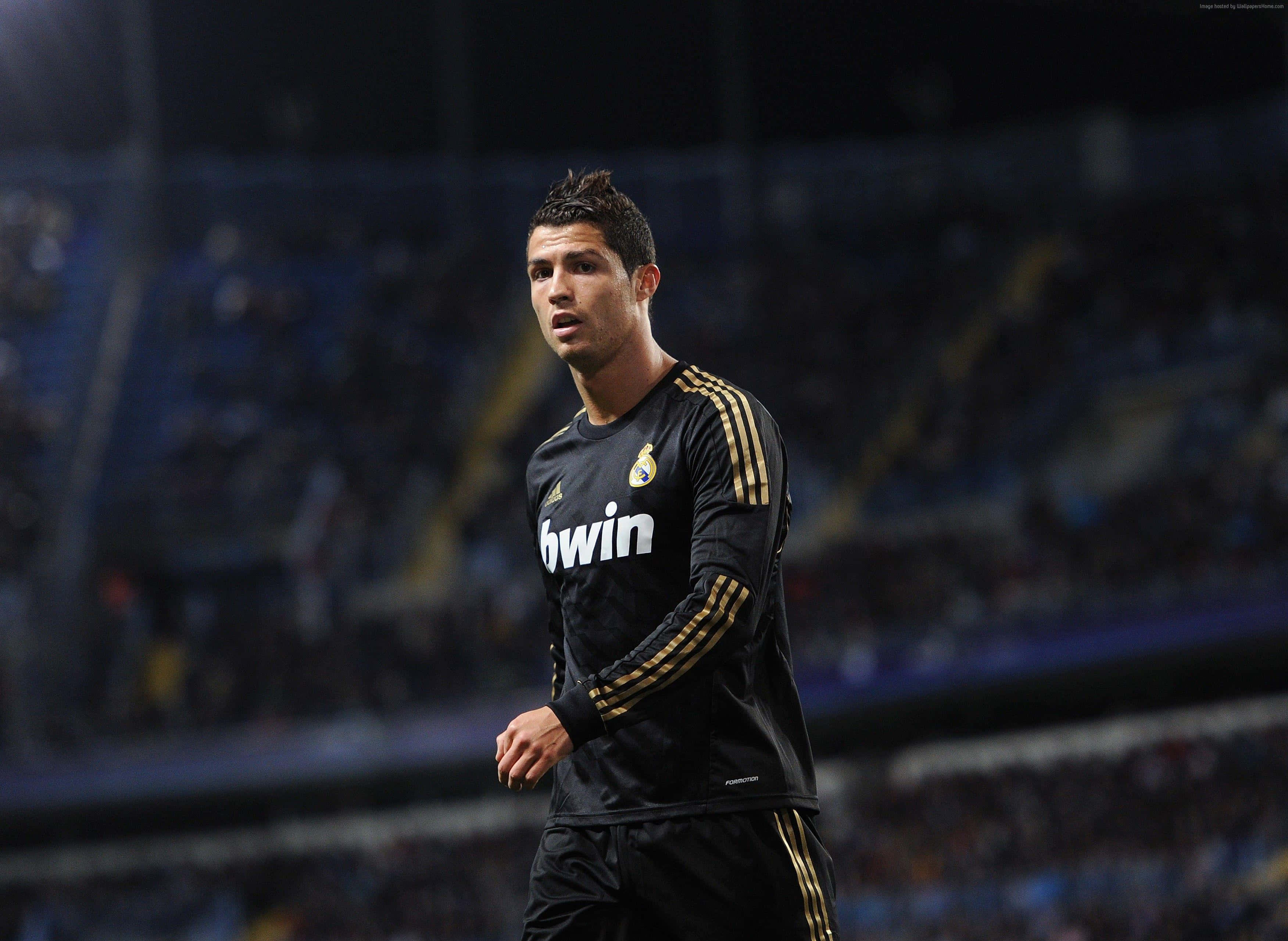 Cristiano Ronaldo conduce el balón por la cancha durante un partido de fútbol Fondos de pantalla
