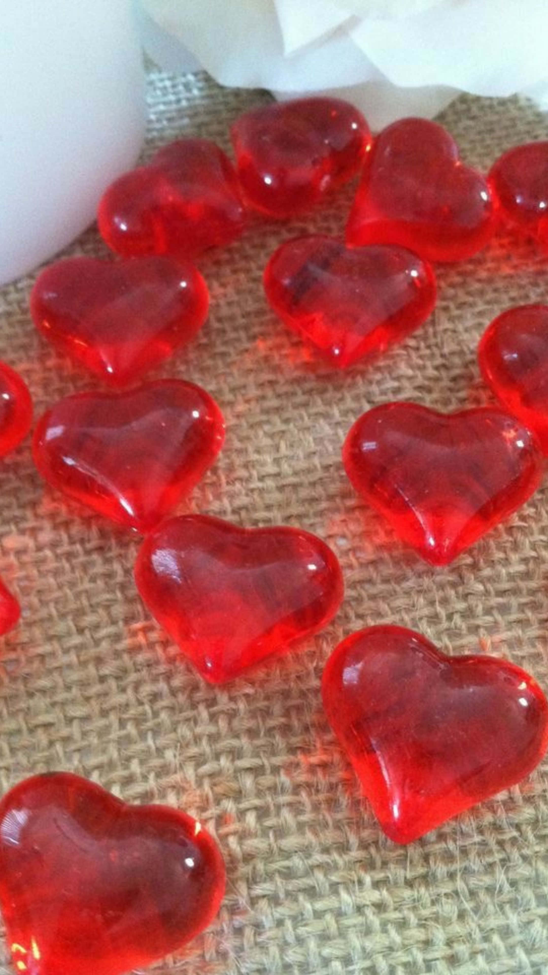 cuentas de vidrio rojas en forma de corazón sobre una mesa Fondos de pantalla