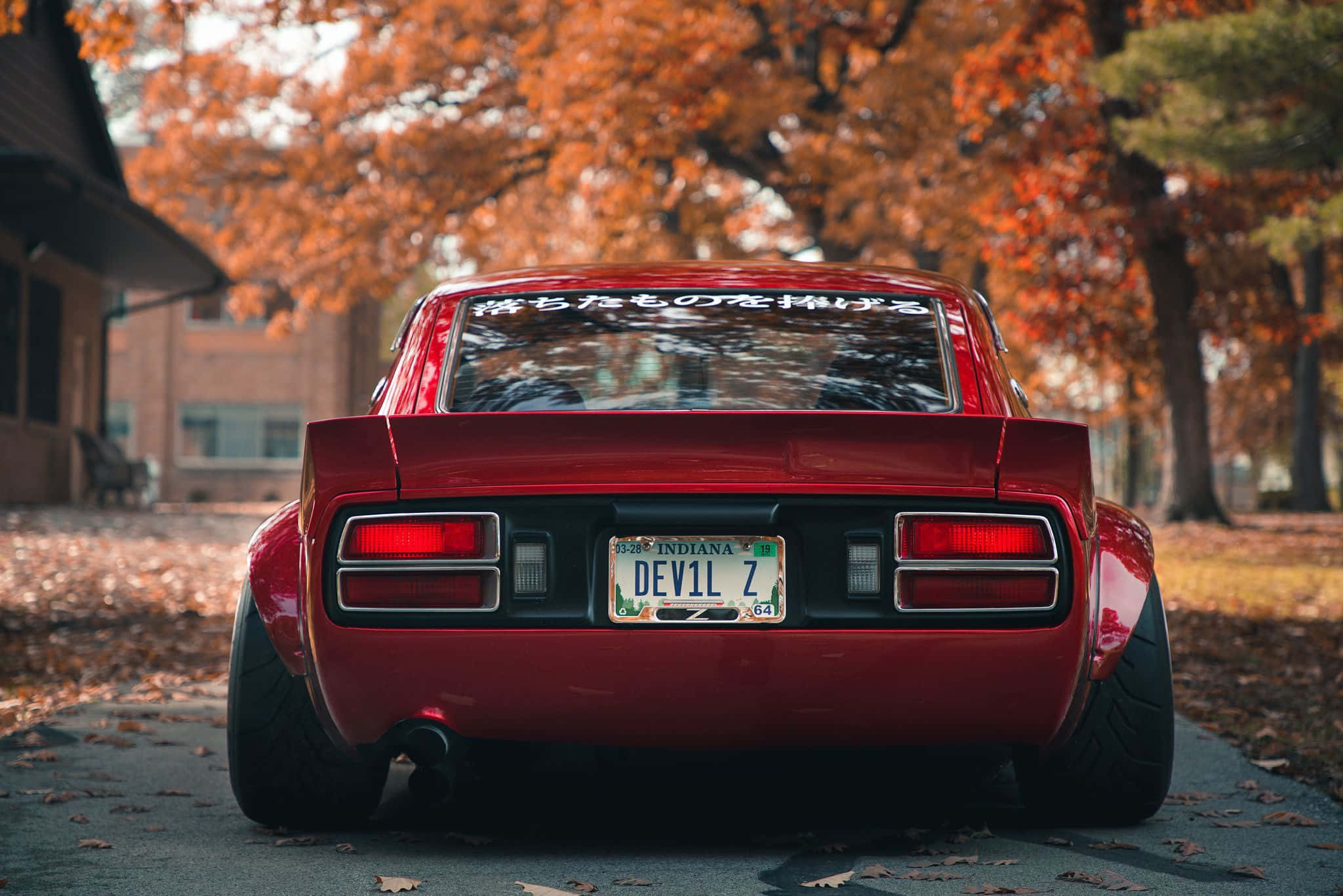 Datsun rojo y elegante estacionado en una calle de la ciudad Fondos de pantalla