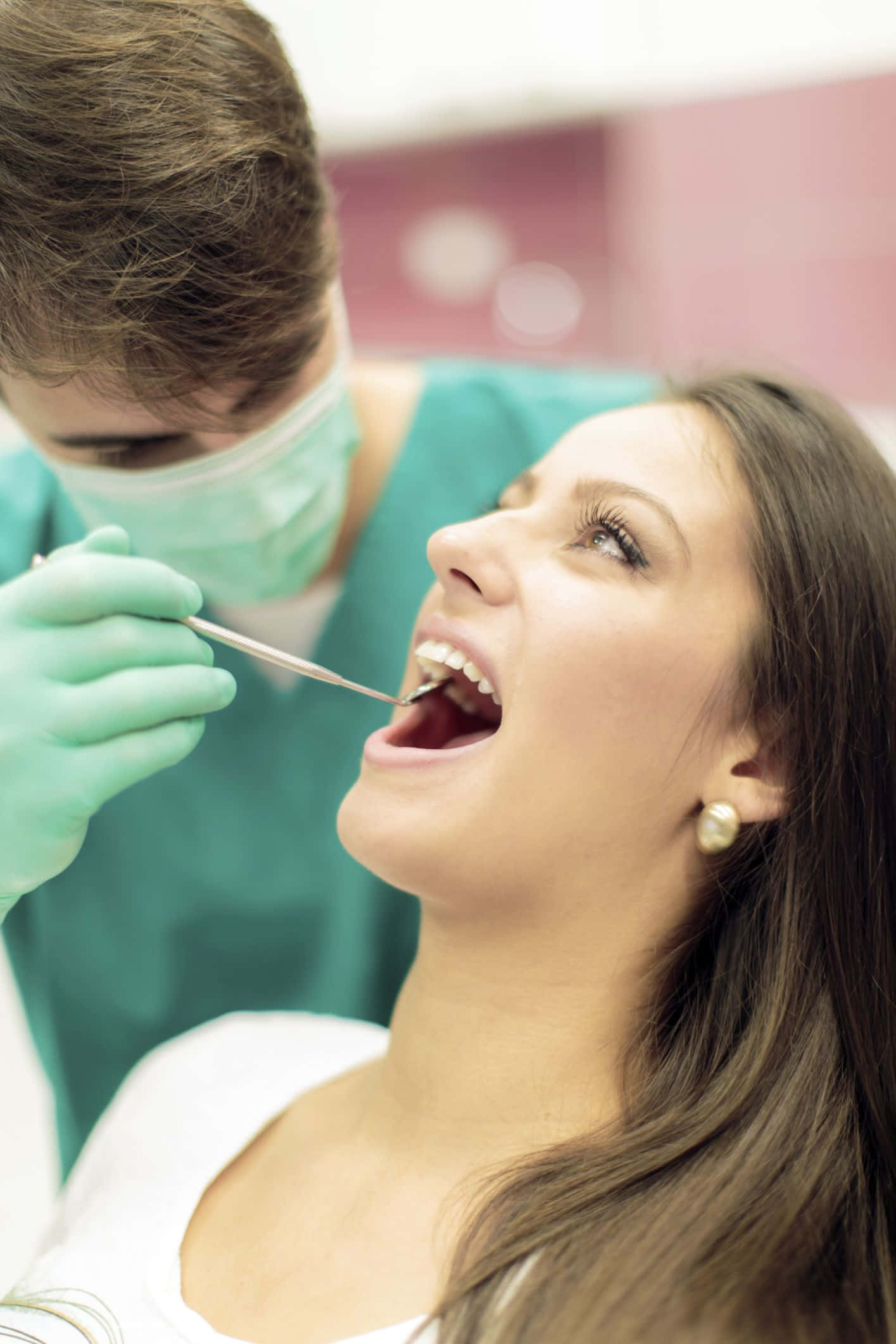 Dentista examinando paciente con herramientas dentales Fondos de pantalla