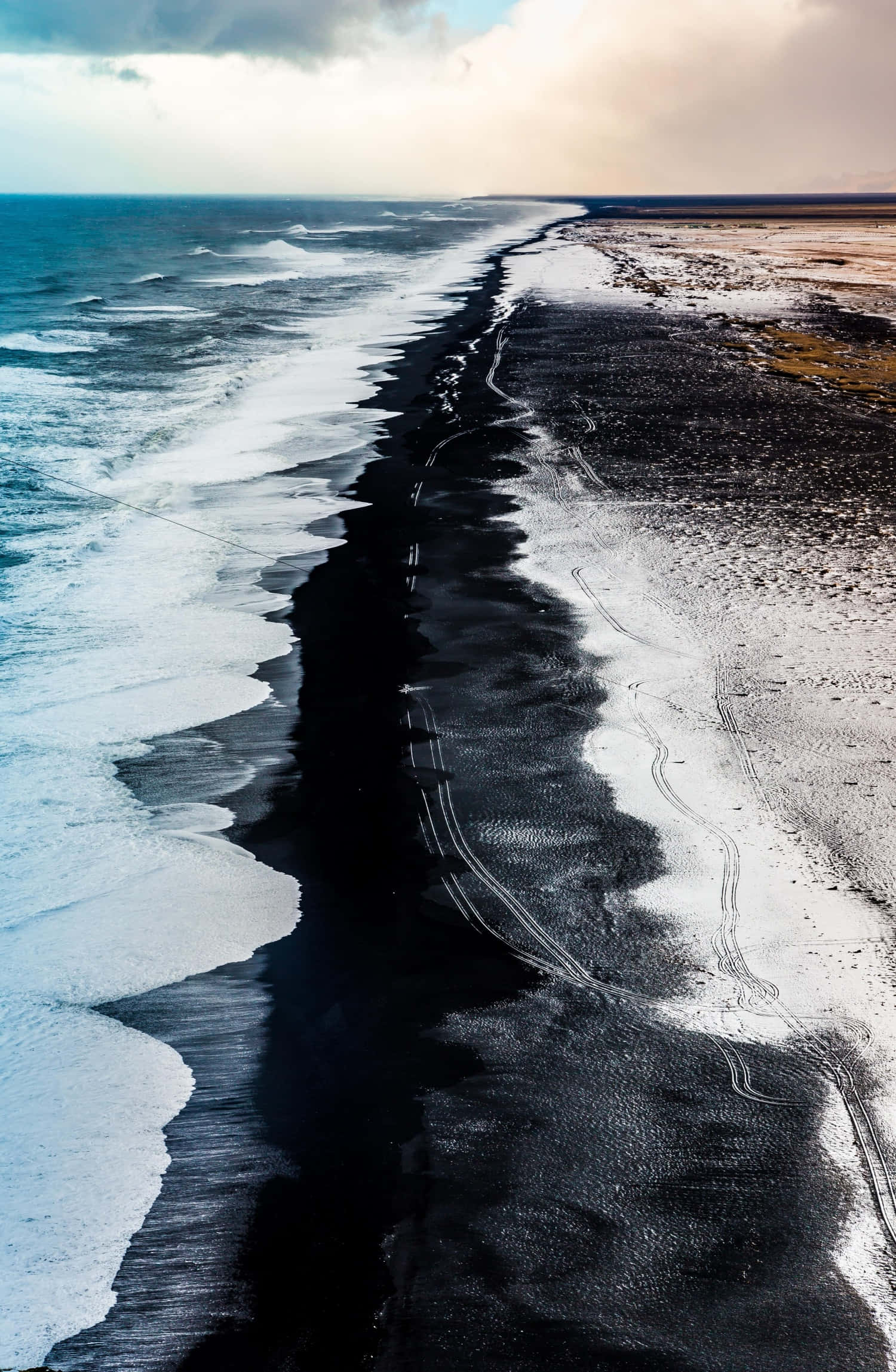 Disfruta la belleza de la playa de arena oscura Fondos de pantalla