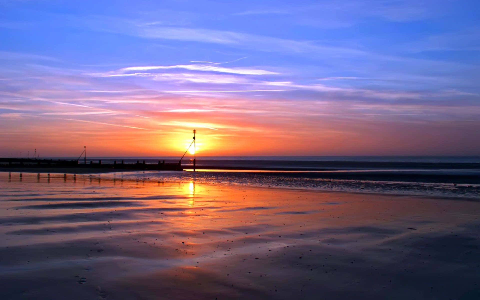 Disfruta la dorada belleza de una playa al atardecer en calma Fondos de pantalla