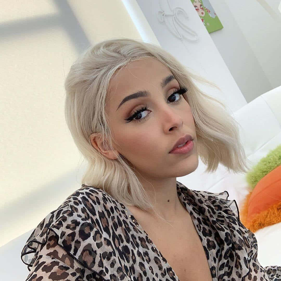 Doja Cat mostrando su belleza con sombra de ojos brillante y una sonrisa radiante. Fondos de pantalla