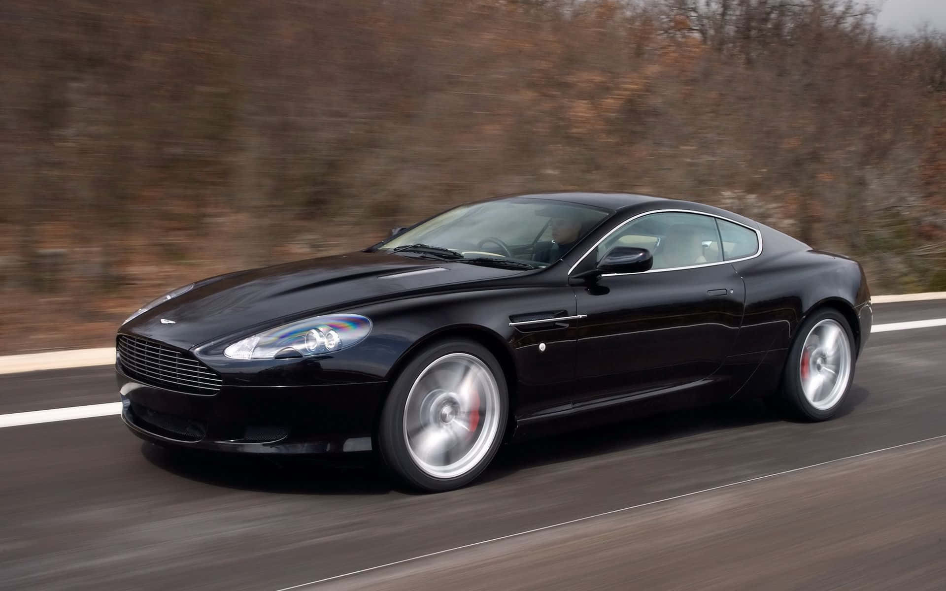 Elegante Aston Martin DB9 en una carretera abierta Fondos de pantalla