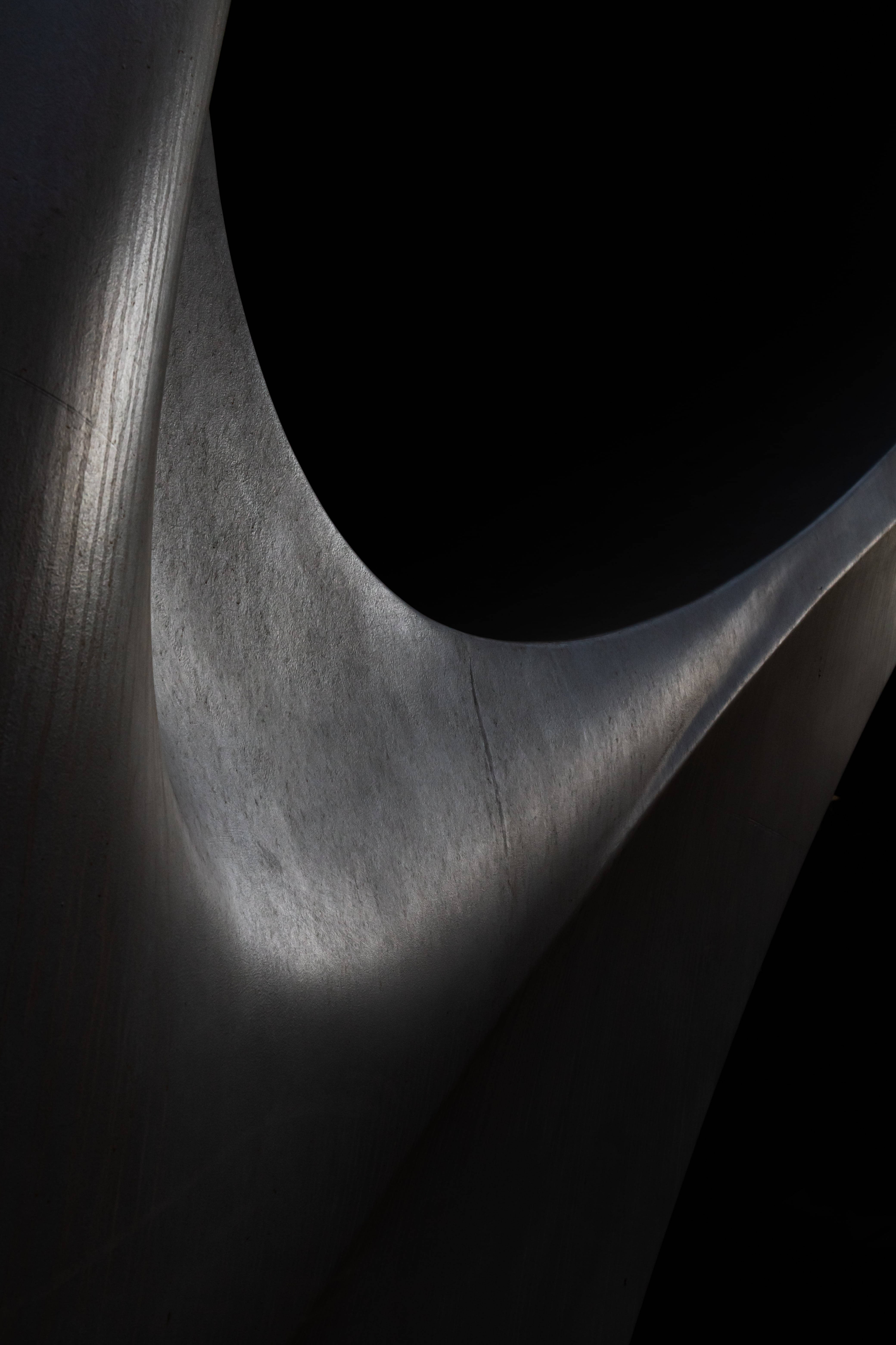 Escultura abstracta negra en una habitación con poca luz Fondos de pantalla