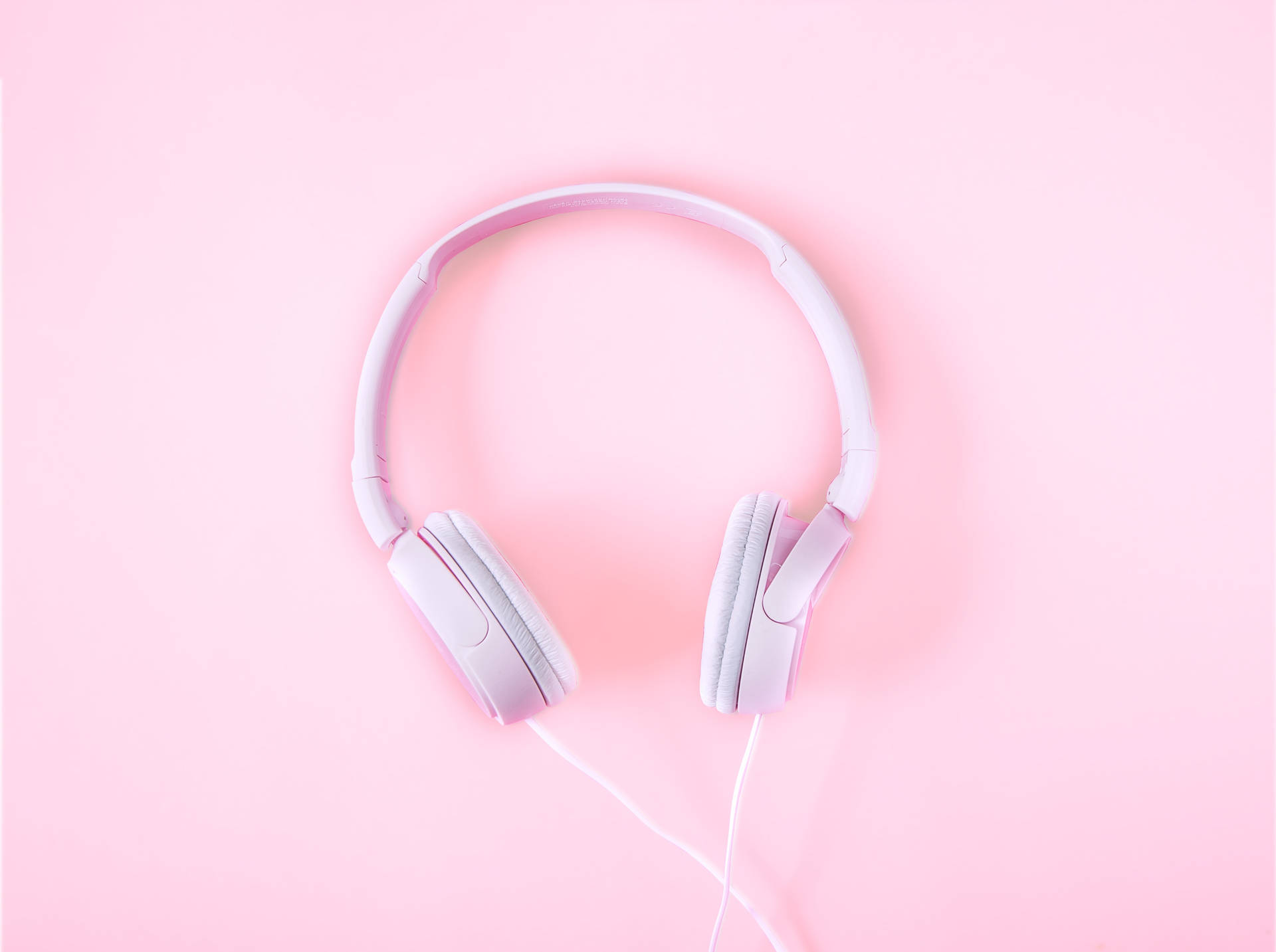 Fondo de pantalla minimalista de audífonos rosas lisos.