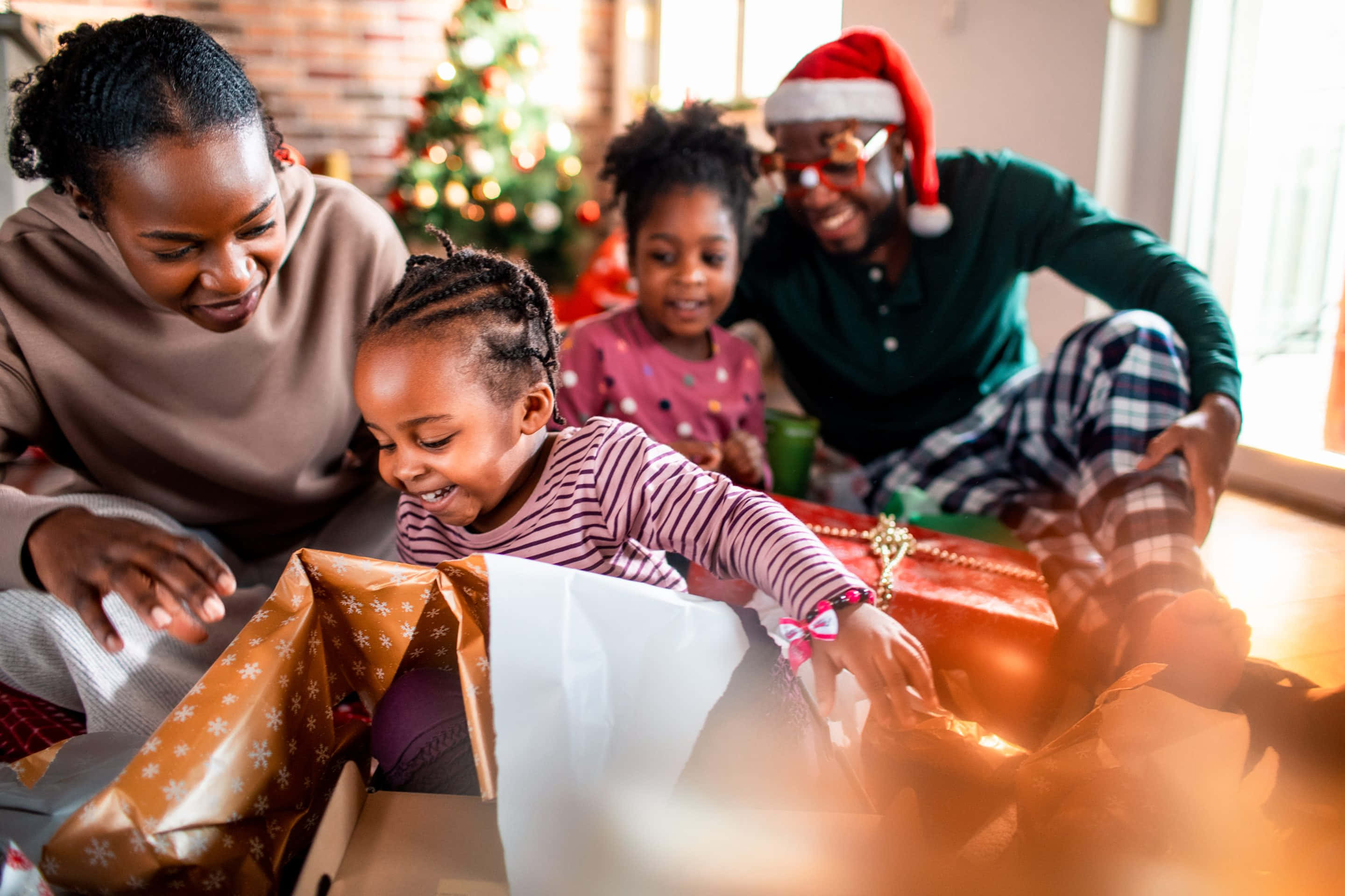 Familia afroamericana abriendo regalos de Navidad Fondos de pantalla