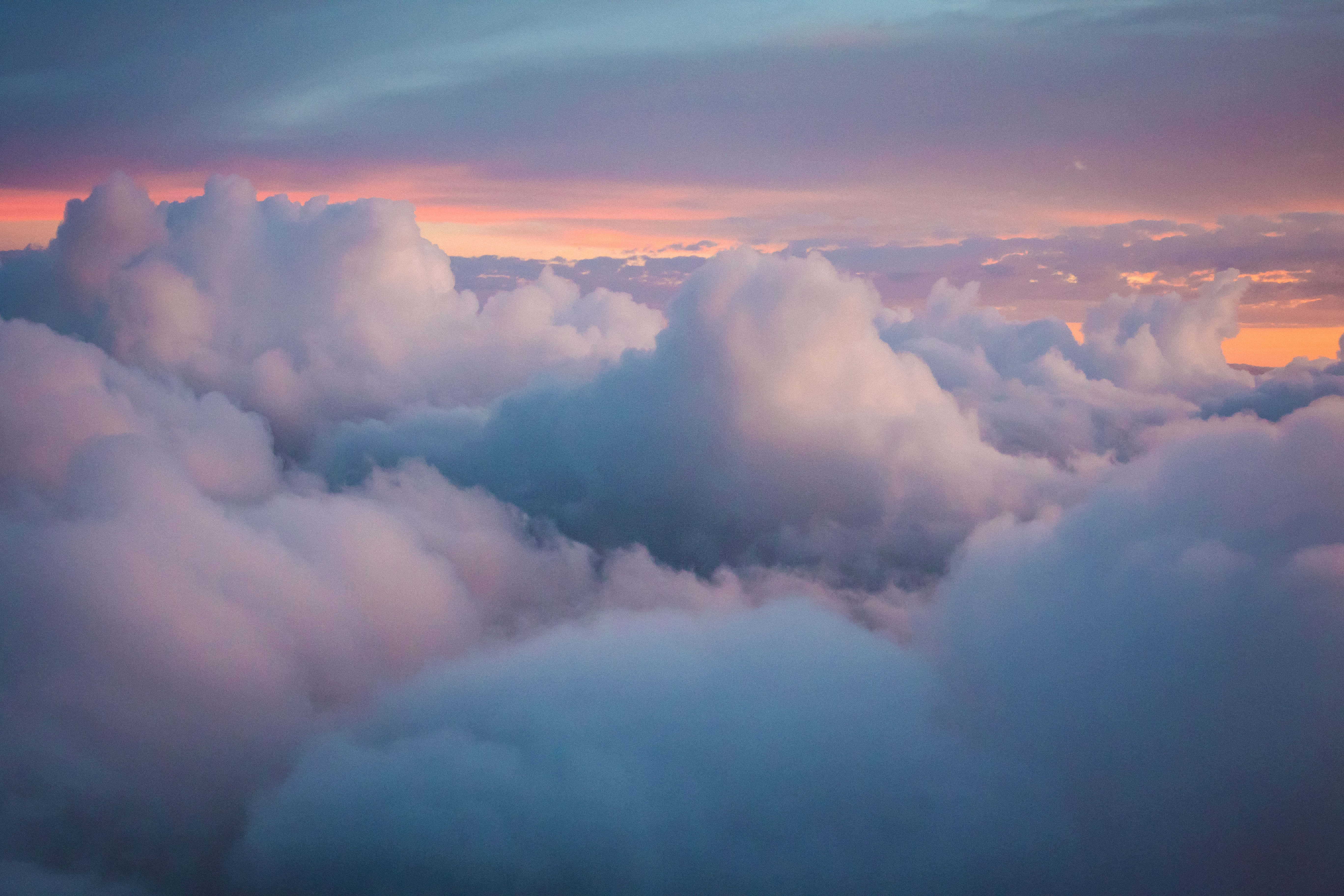 Fondo de nubes blancas esponjosas con tonos anaranjados Fondos de pantalla