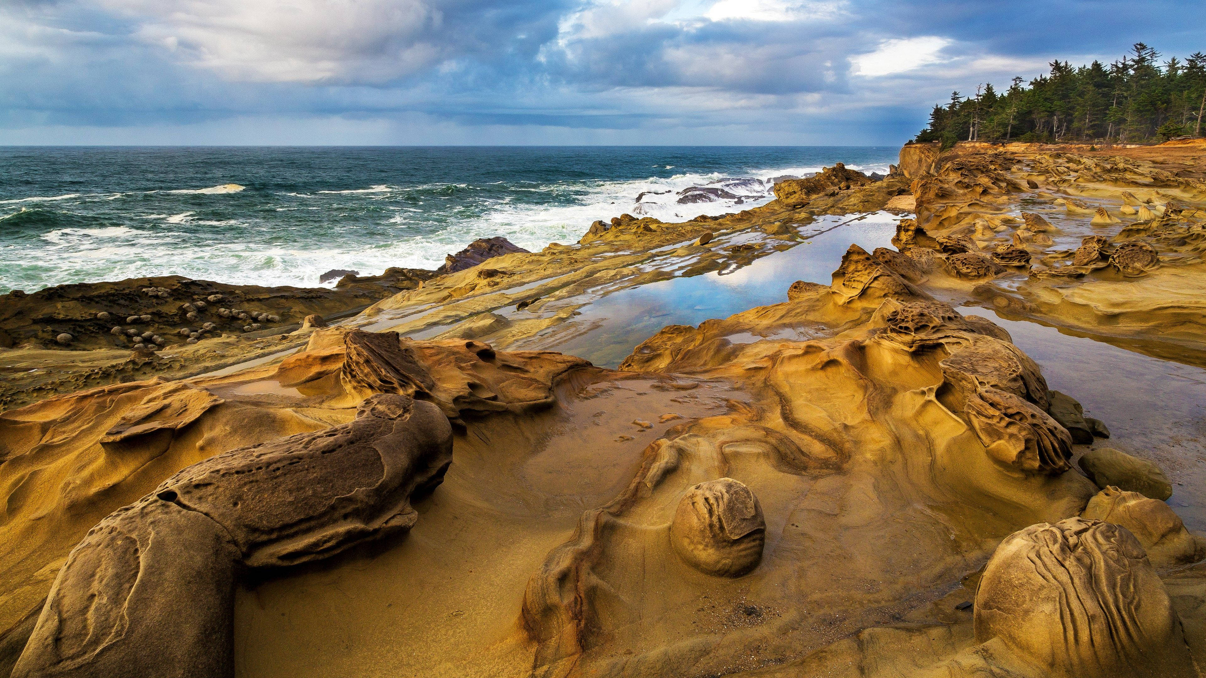 Formaciones rocosas en una exuberante playa costera Fondos de pantalla