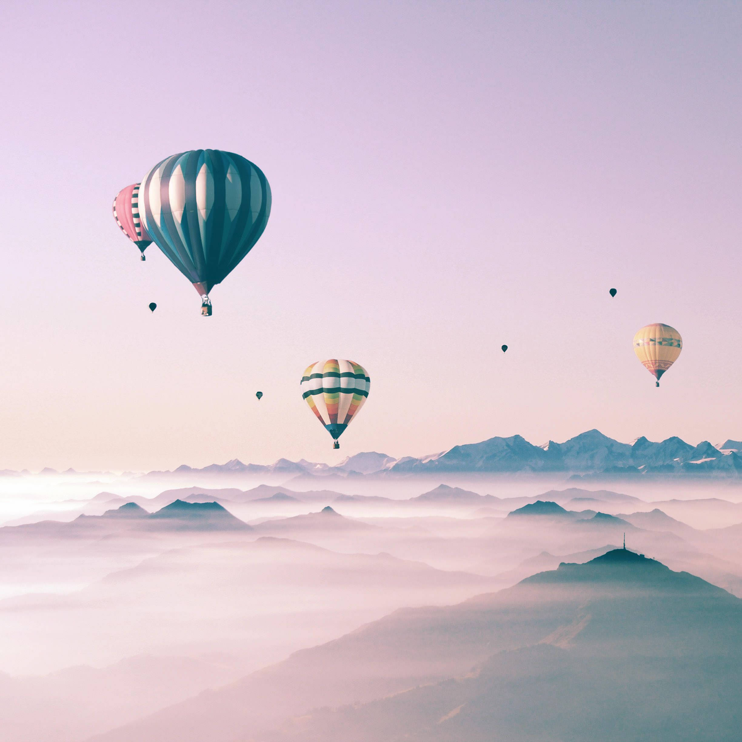 Globos aerostáticos coloridos surcando un hermoso cielo, mostrados en un lindo iPad. Fondos de pantalla