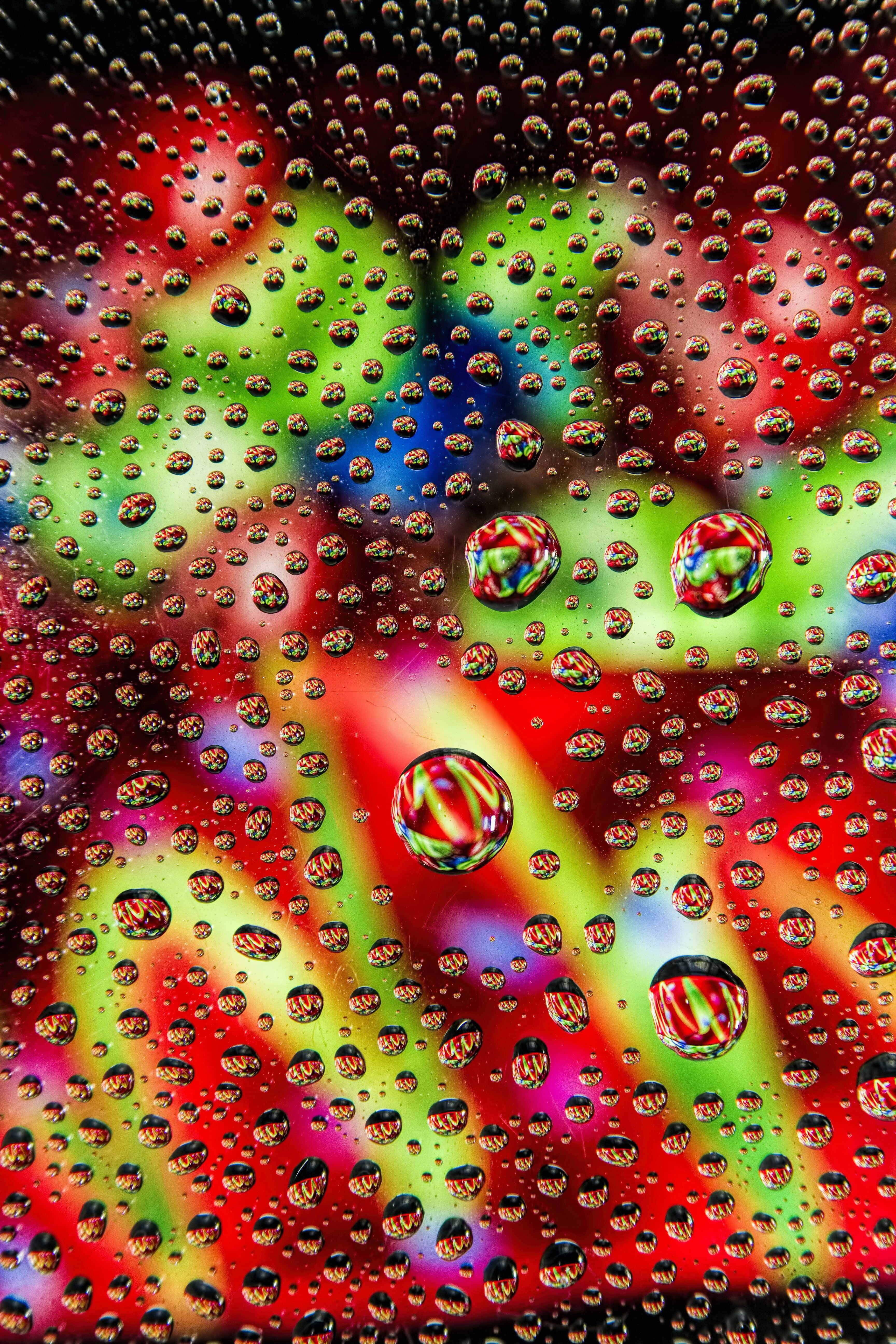 gotas de agua sobre un vidrio con luces coloridas Fondos de pantalla