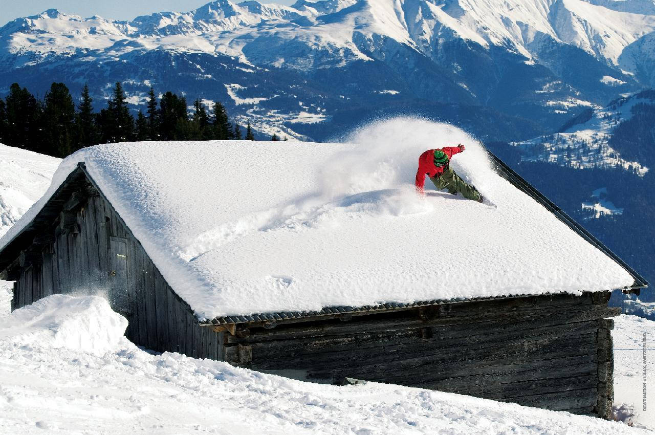 Hombre con Tabla de Nieve Deslizándose en un Techo Fondos de pantalla
