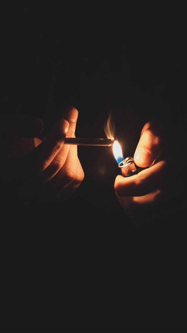 Fondo de pantalla para iPhone de un cigarro encendido en la oscuridad