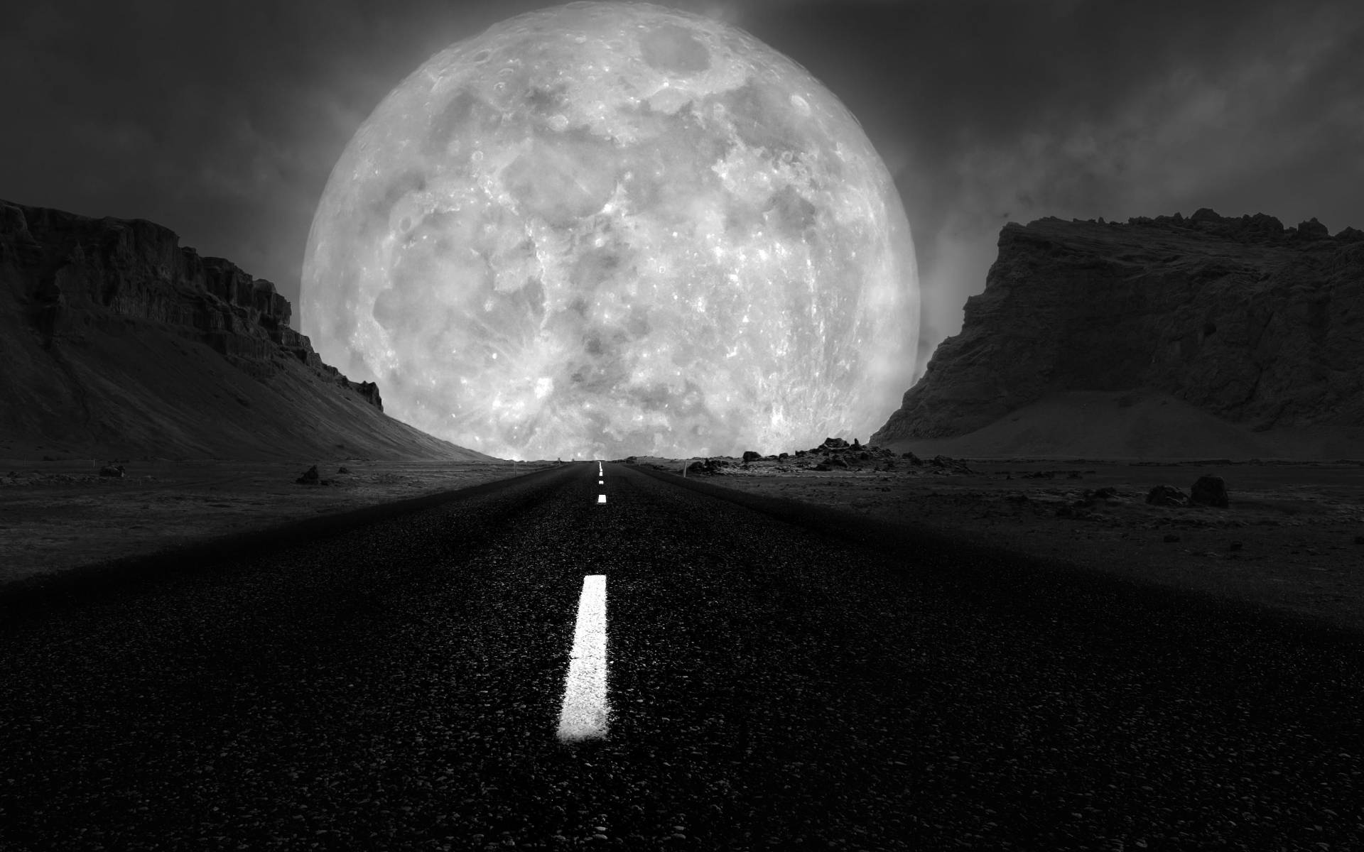 Impactante imagen de la luna galáctica en escala de grises sobre una carretera solitaria Fondos de pantalla