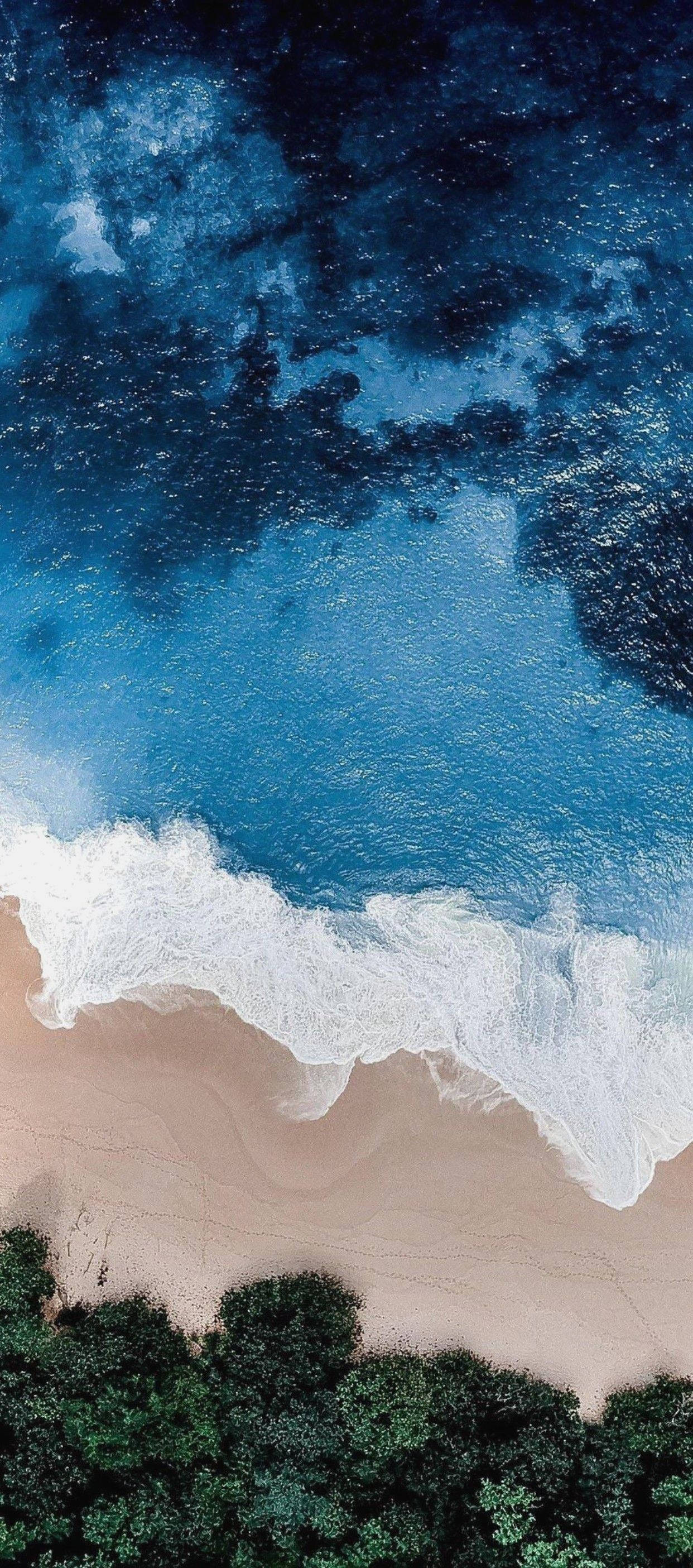 iPhone 11 elevándose sobre la costa Fondos de pantalla