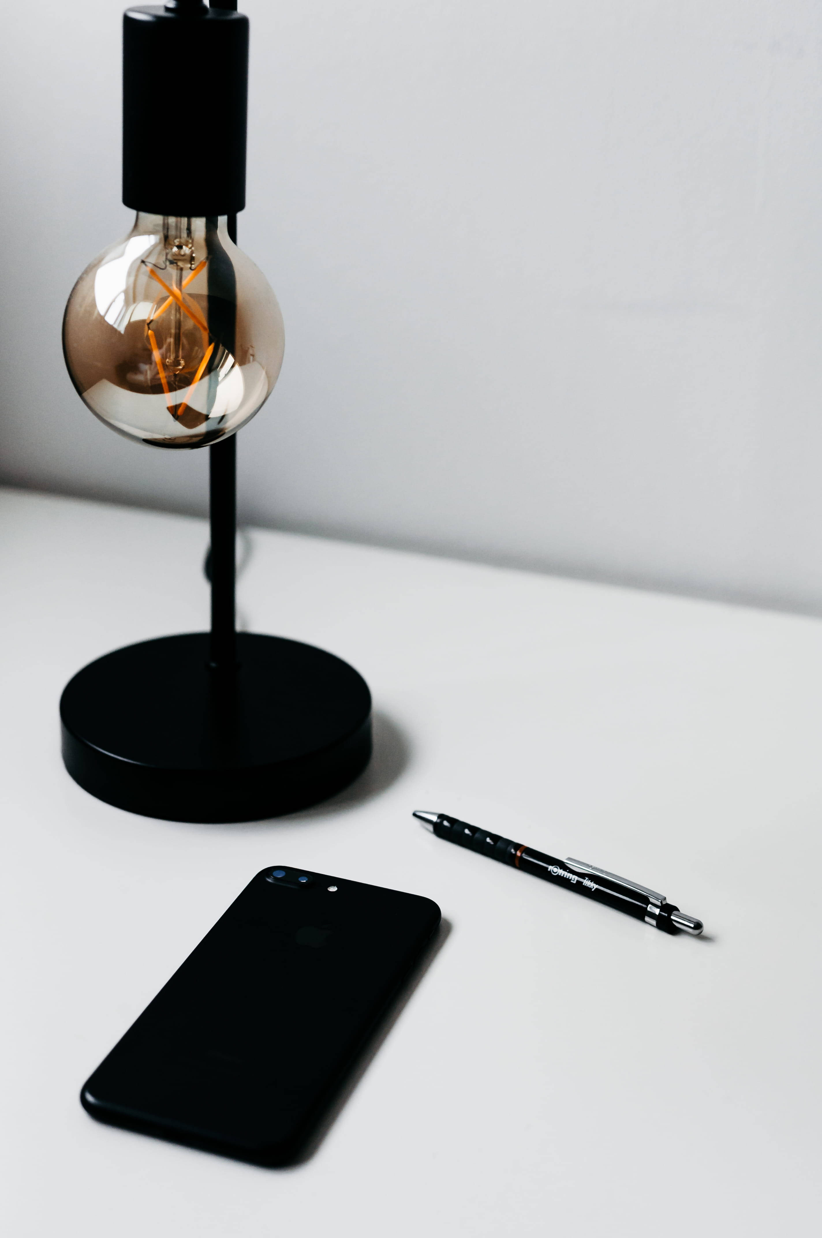 iPhone iluminado sobre escritorio minimalista Fondos de pantalla