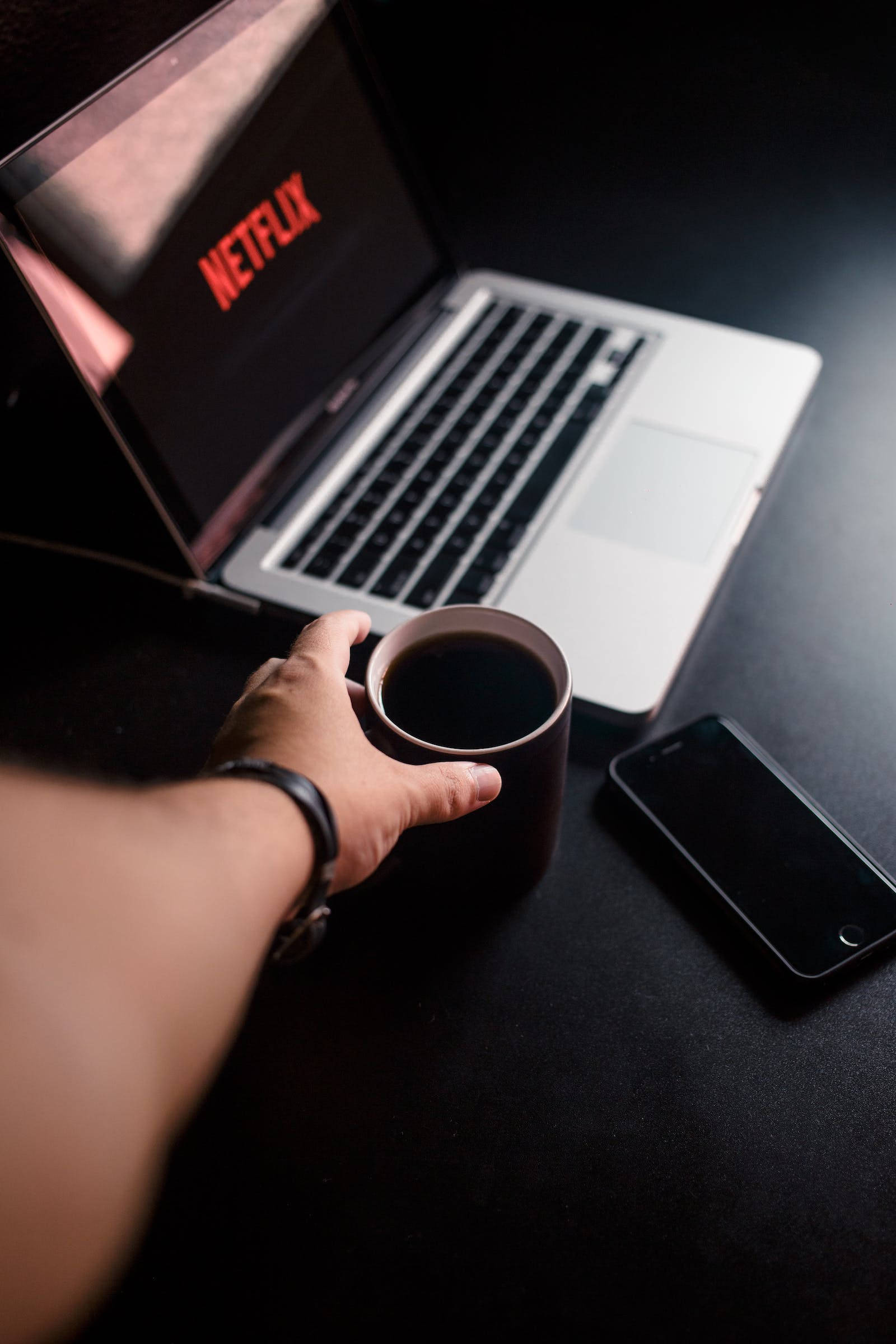 iPhone oscuro con MacBook y taza Fondos de pantalla