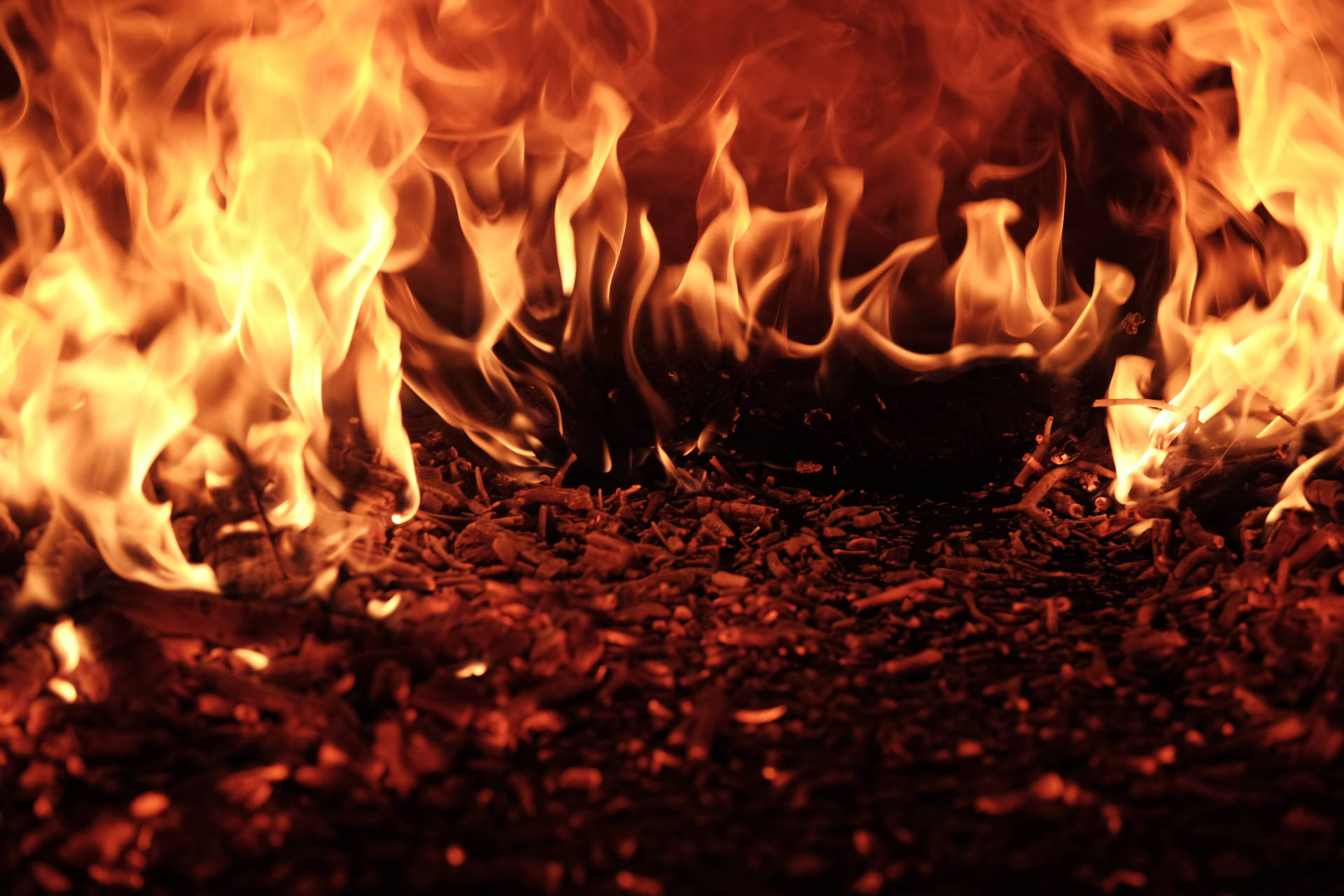 Fuego ardiente con llamas amarillas y anaranjadas brillantes que lo envuelven todo a su paso.