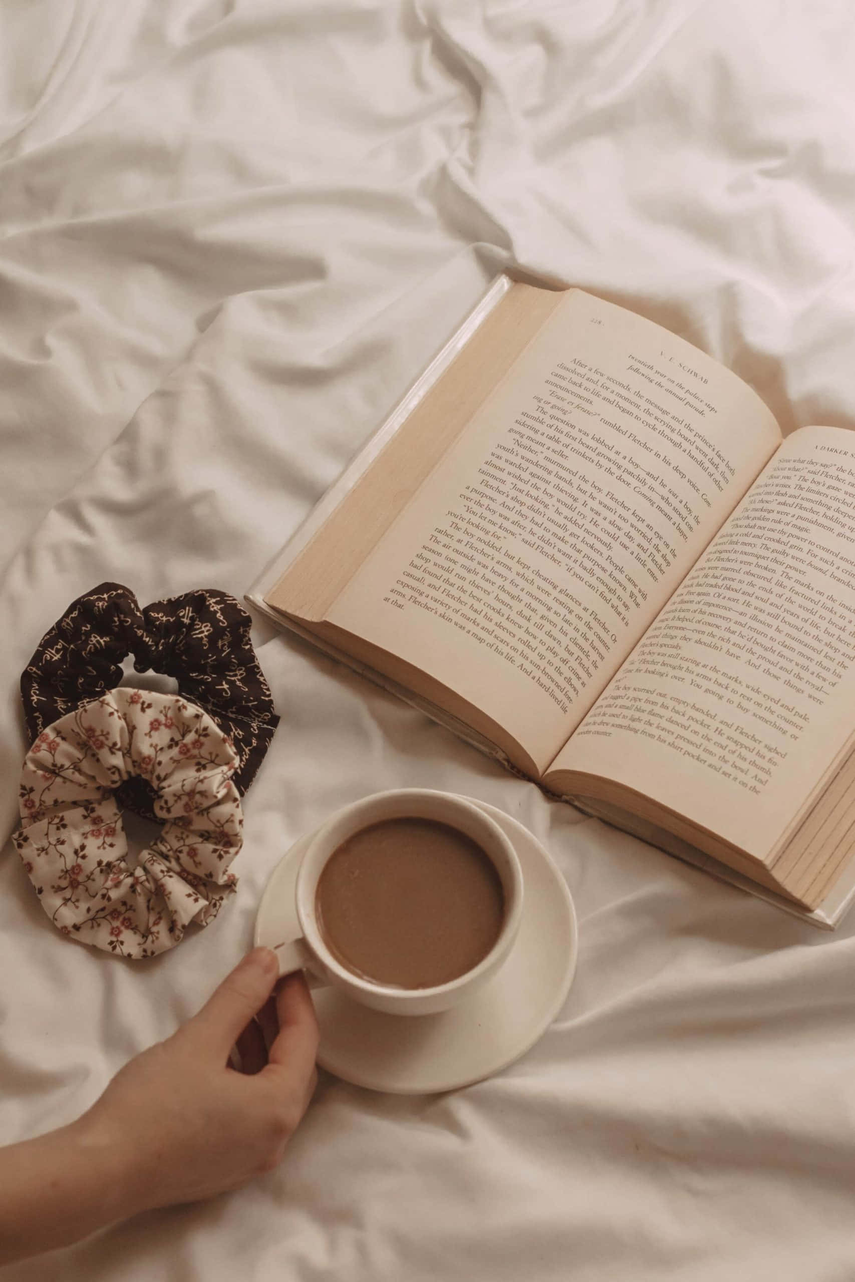 la mano de una mujer sosteniendo un libro y una taza de café Fondos de pantalla
