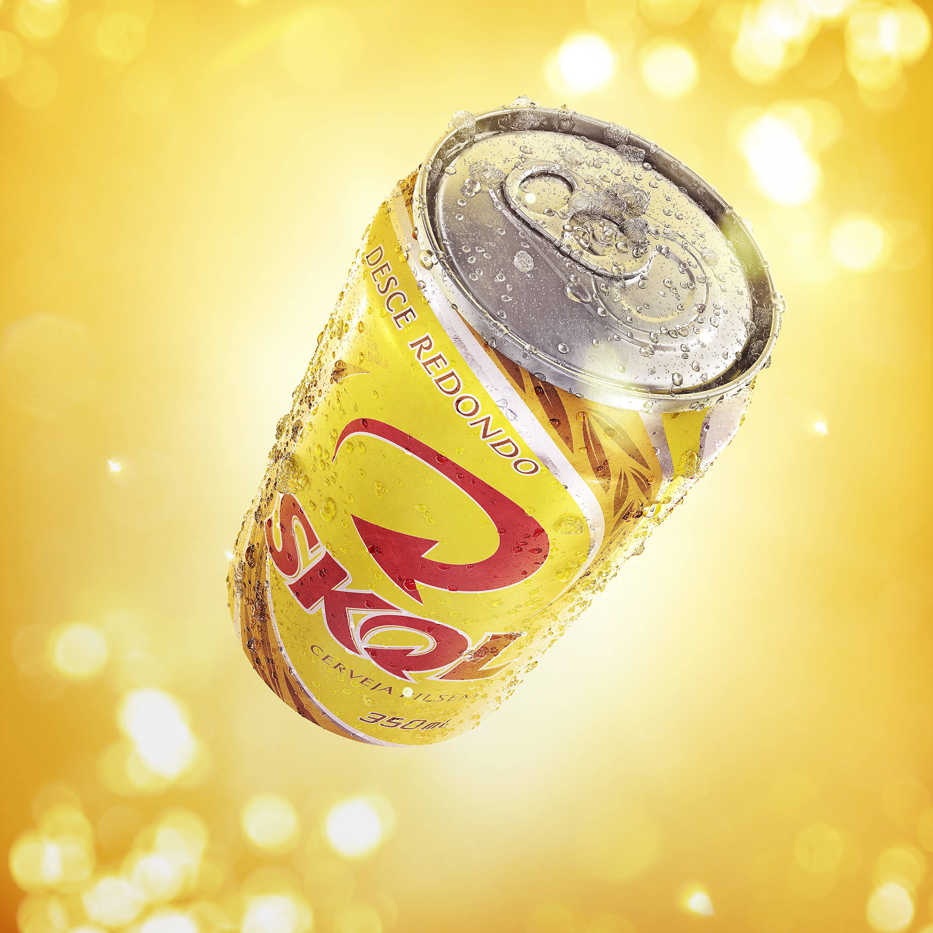 Lata fría de cerveza Skol sobre fondo amarillo vibrante Fondos de pantalla