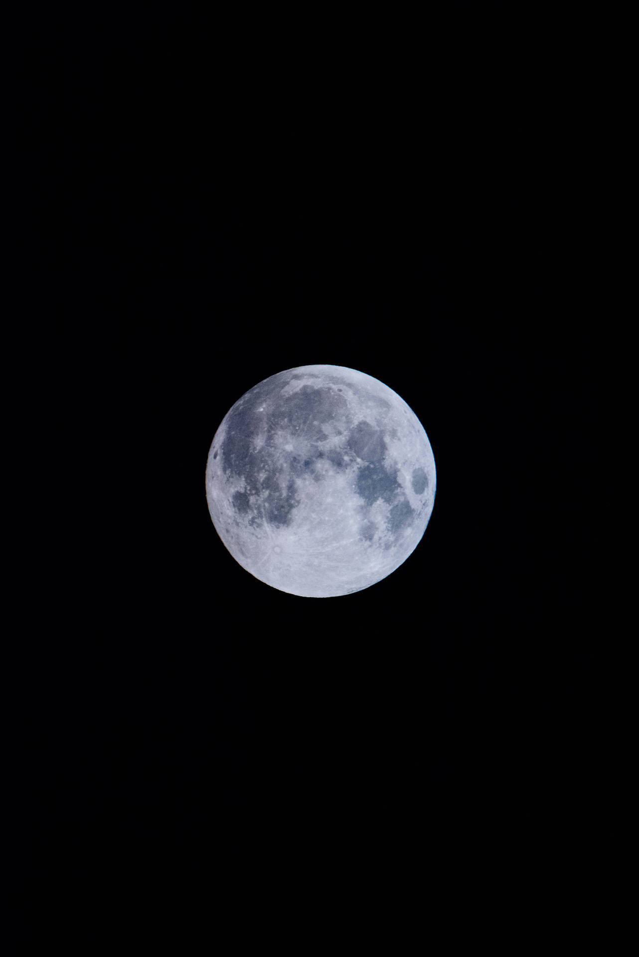 Luna llena brillando intensamente sobre el oscuro cielo de medianoche. Toma satelital desde el espacio.