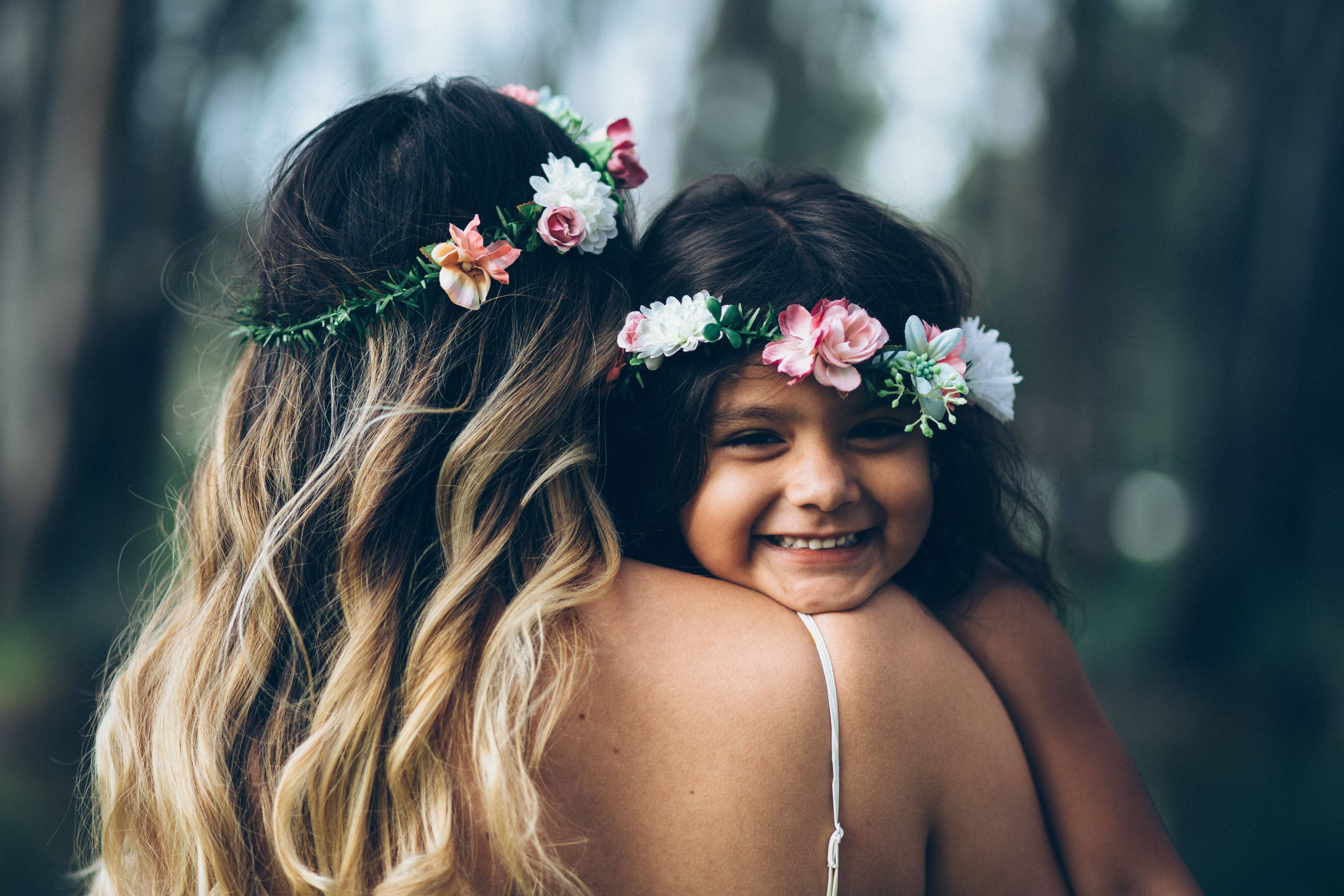 Madre e hija usando coronas de flores Fondos de pantalla