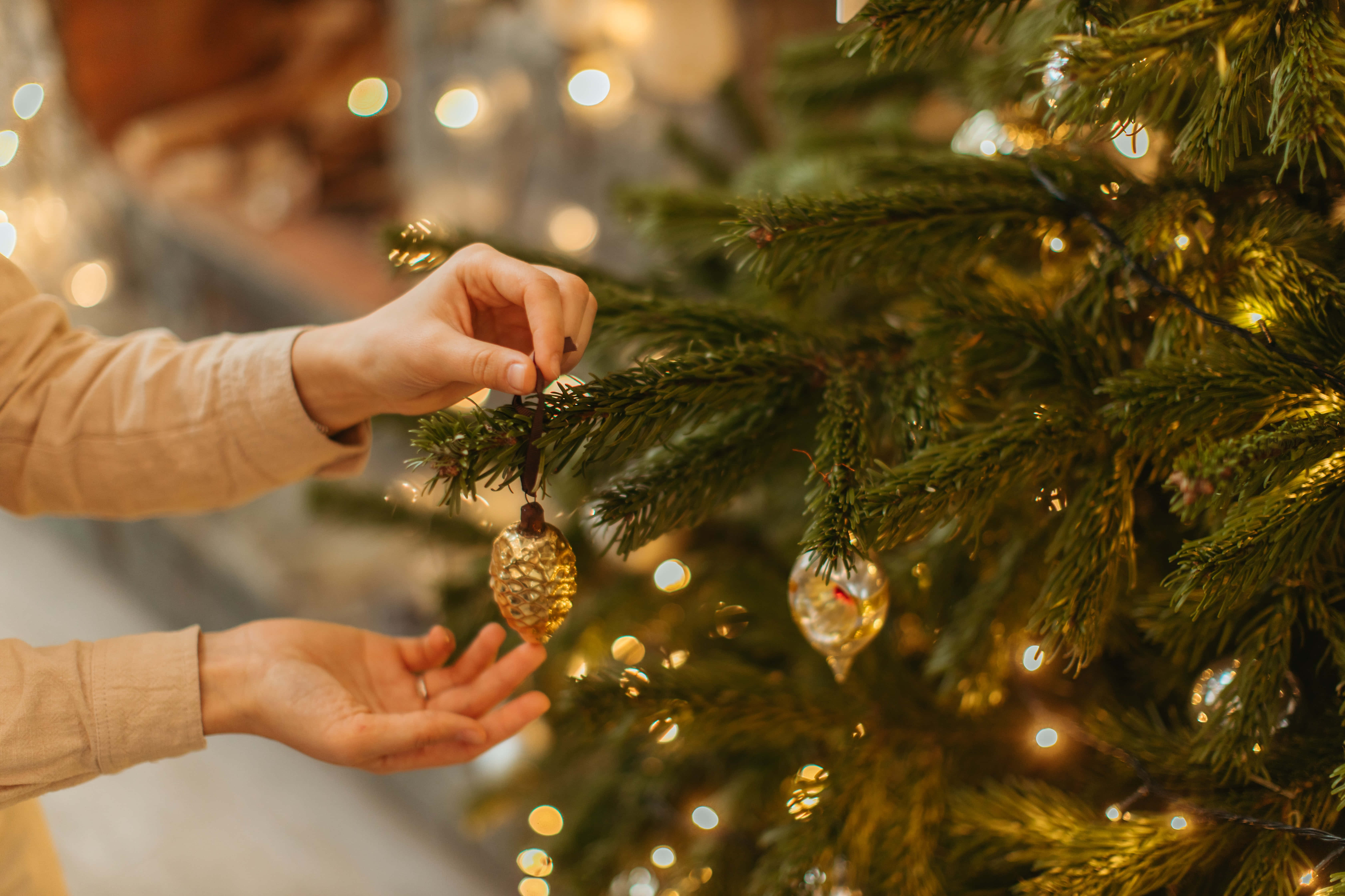 Mano colocando adornos navideños fondo de foto Fondos de pantalla