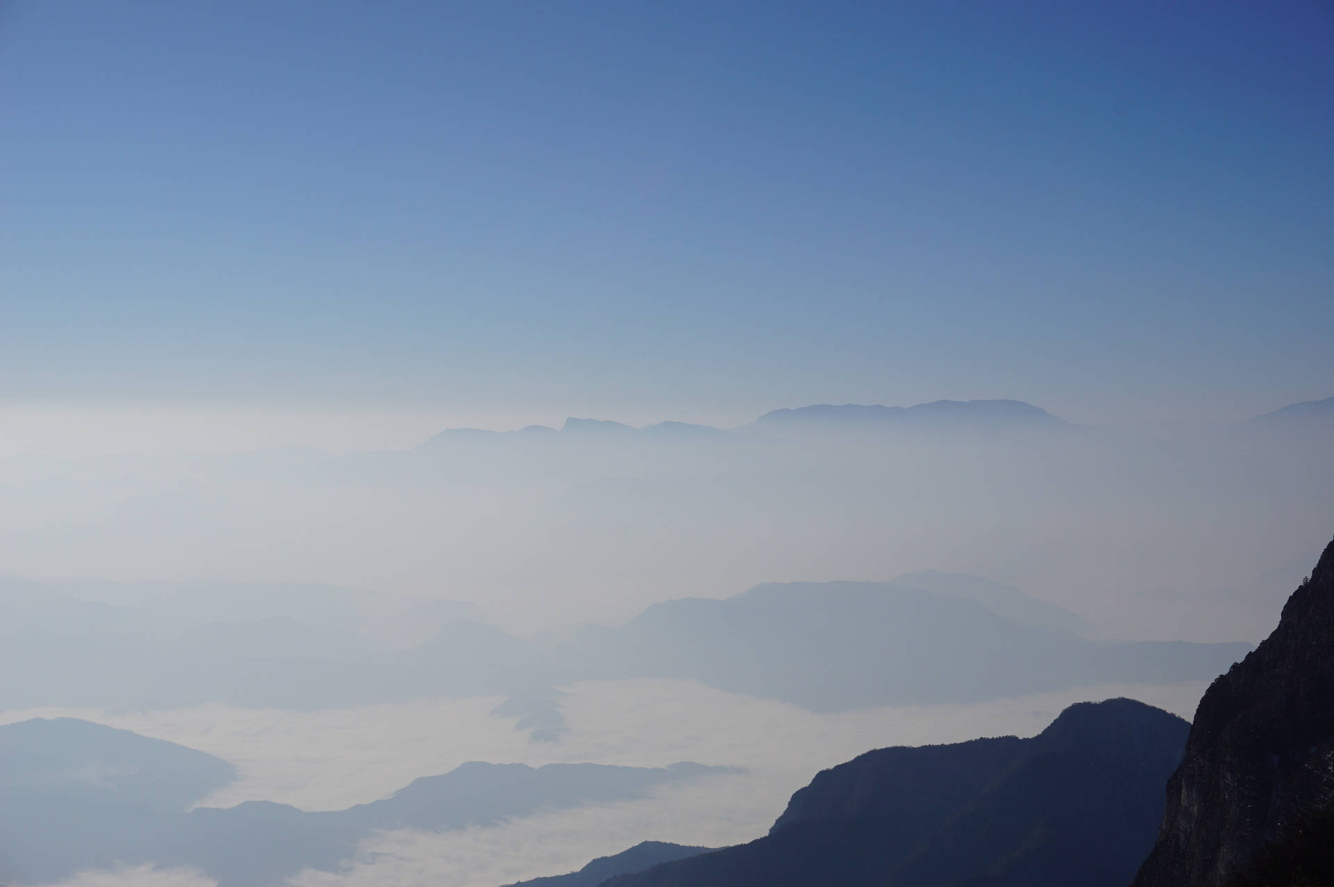 Cielo montañoso con niebla y bruma ocultando las tierras debajo.