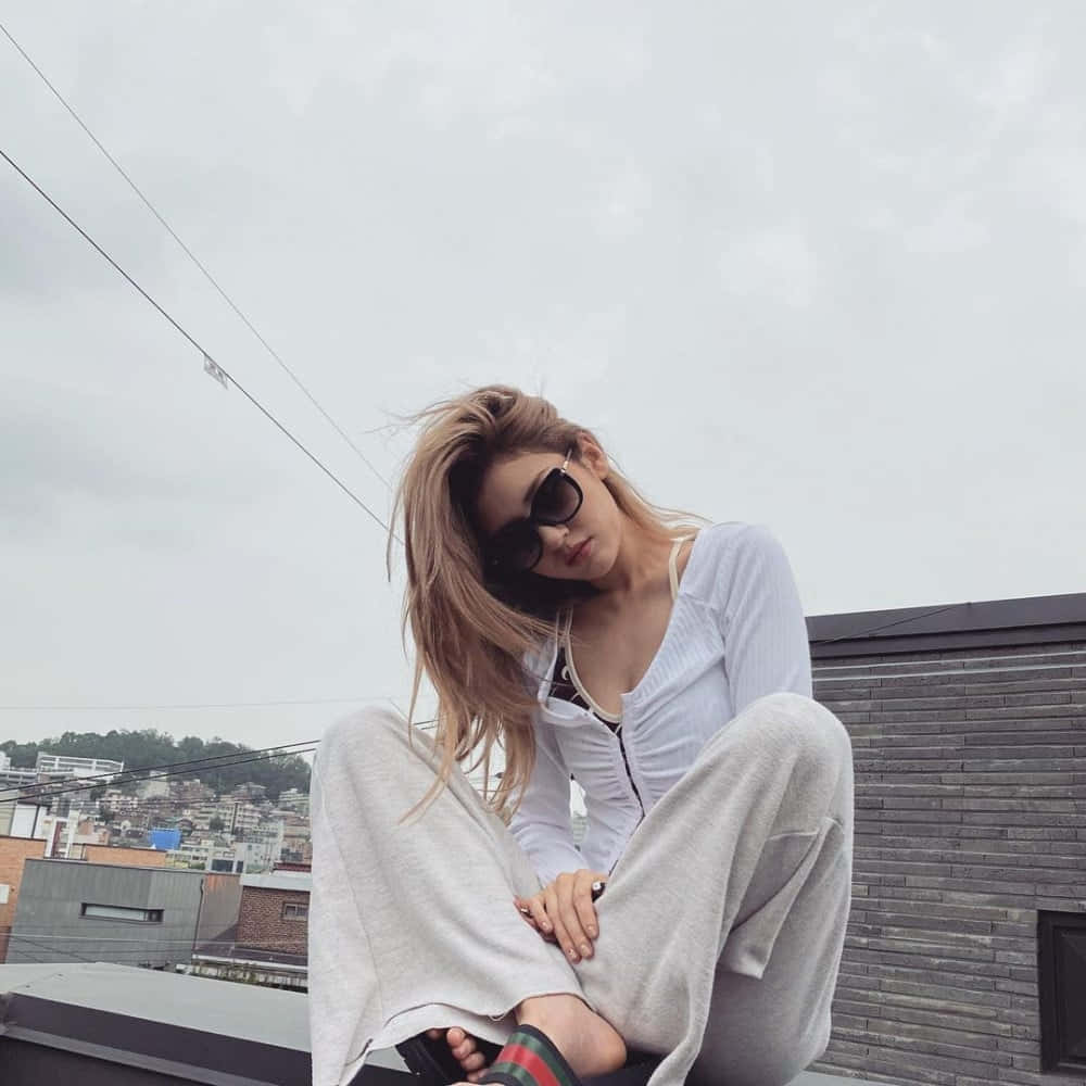 Mujer sentada en un tejado con gafas de sol Fondos de pantalla
