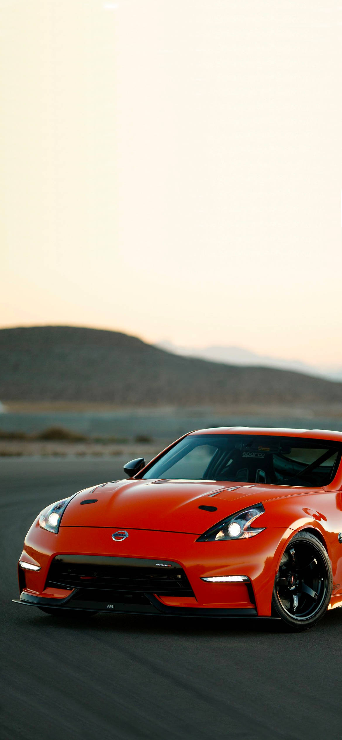 Nissan 370Z rojo con una colina Fondos de pantalla