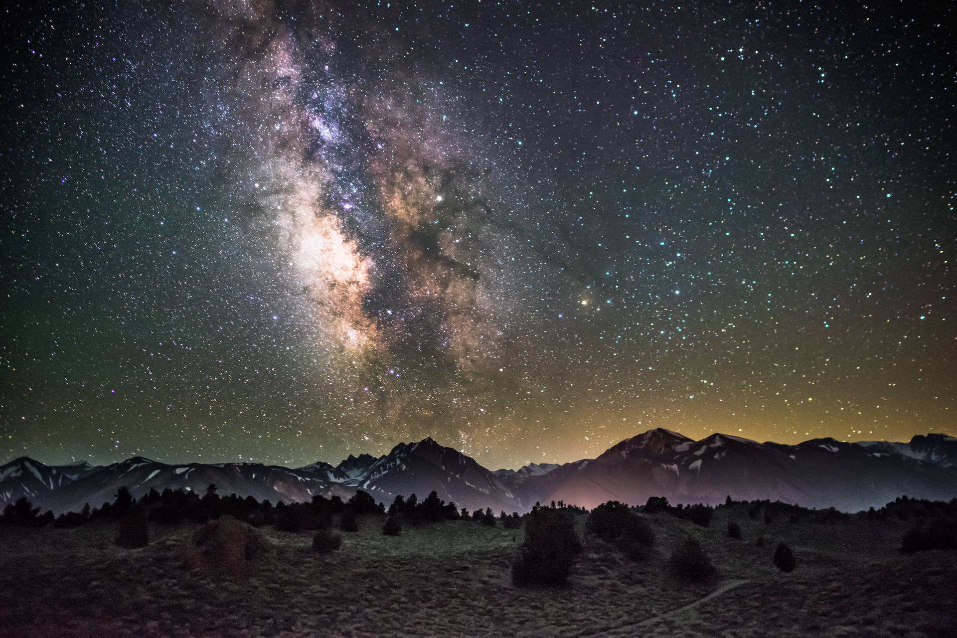 Fondo de pantalla de noche estrellada sobre montañas