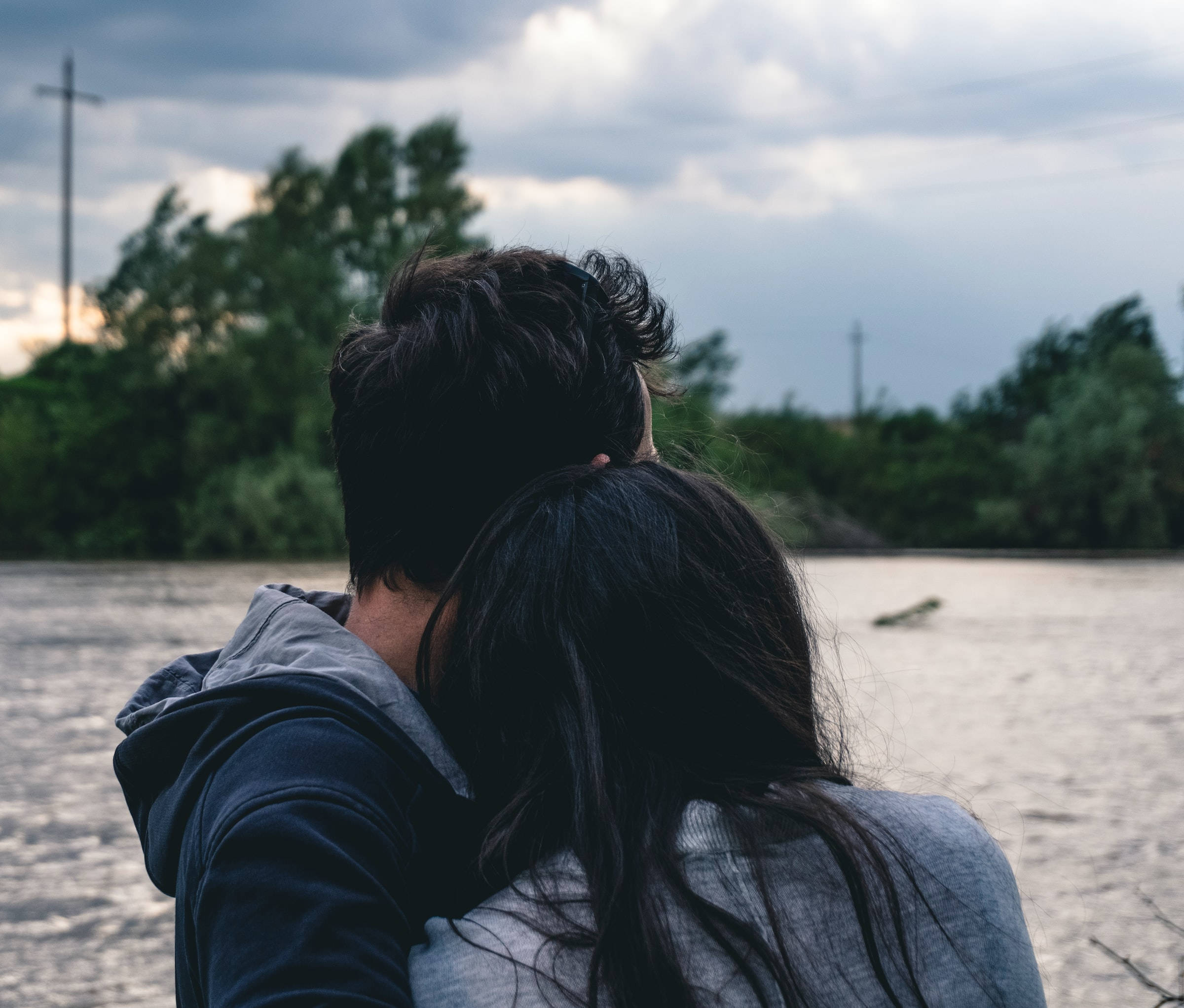 Pareja abrazándose a la orilla del río Fondos de pantalla