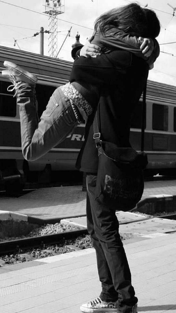 Pareja adorable abrazándose junto al tren en blanco y negro Fondos de pantalla