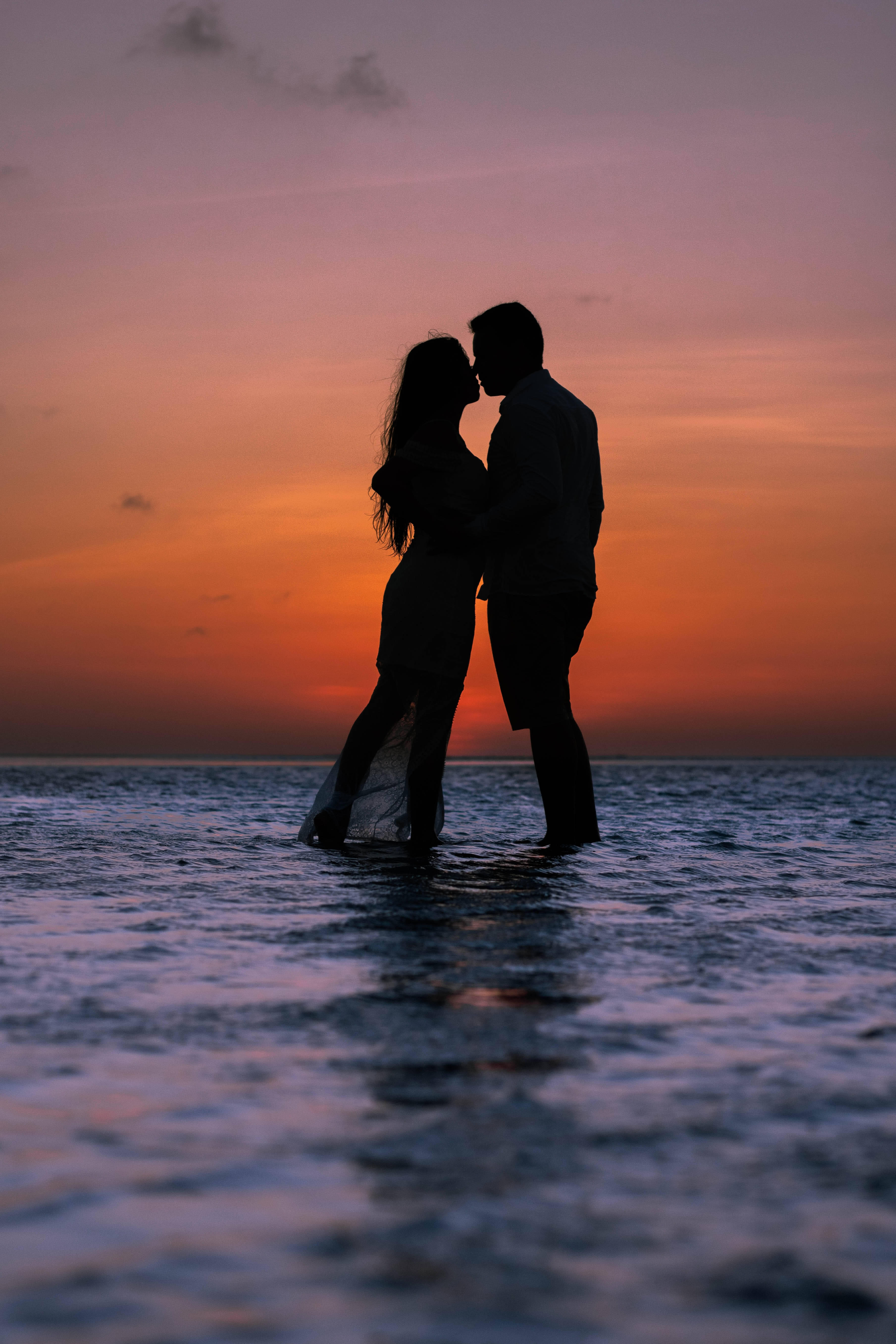 Pareja Romántica Besándose al Atardecer en el Océano Fondos de pantalla