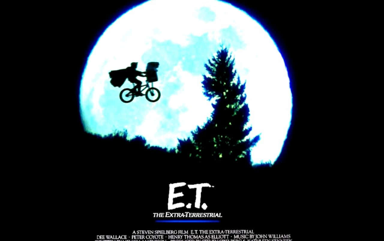 Póster de la película E.T. con un hombre montando una bicicleta en el cielo Fondos de pantalla