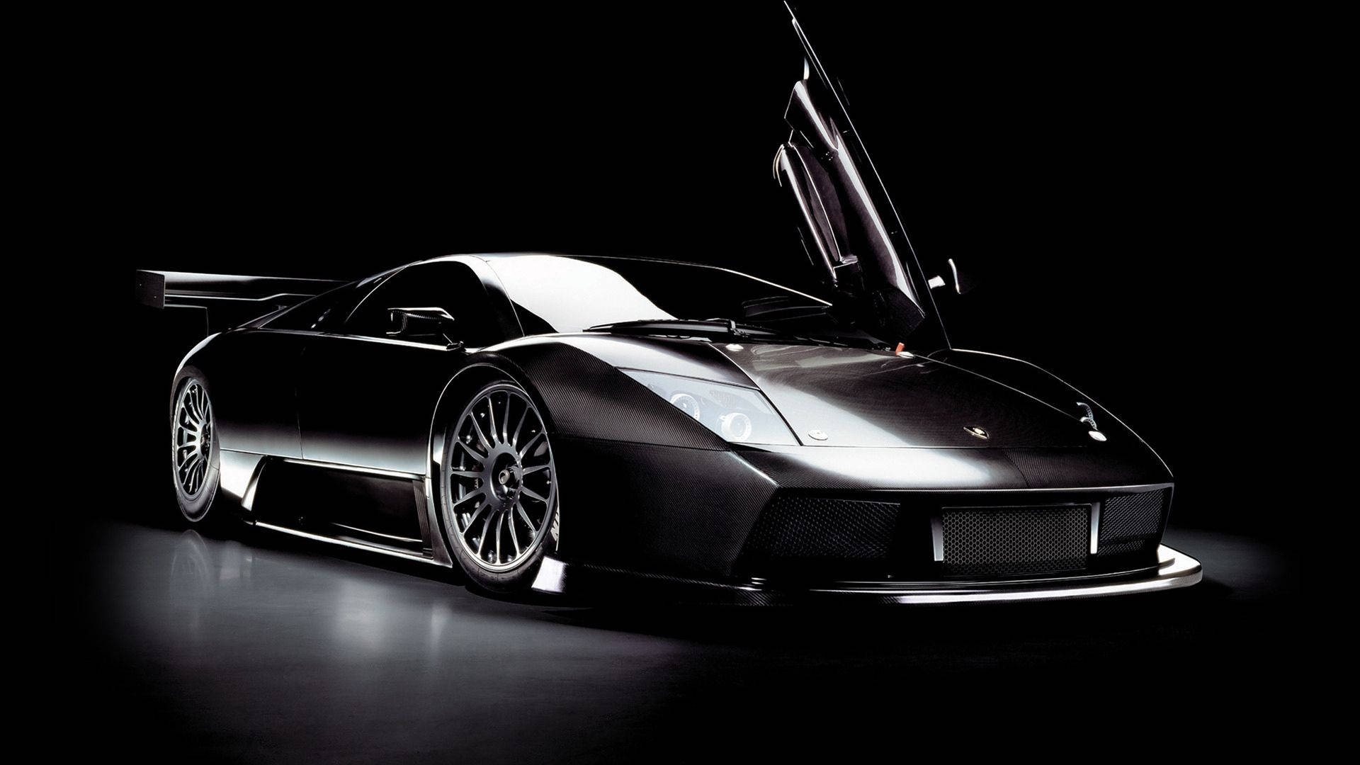 Fondo de pantalla de auto impresionante de un Lamborghini negro con puertas de ala.