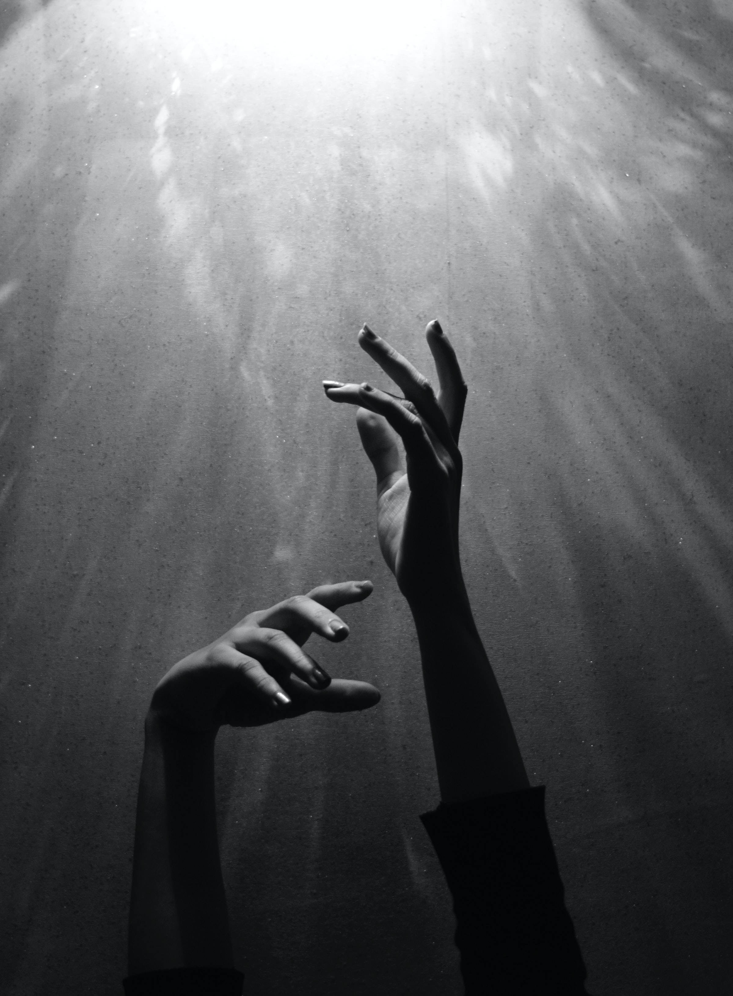 Retrato en Blanco y Negro de Manos Alcanzando la Luz Fondos de pantalla