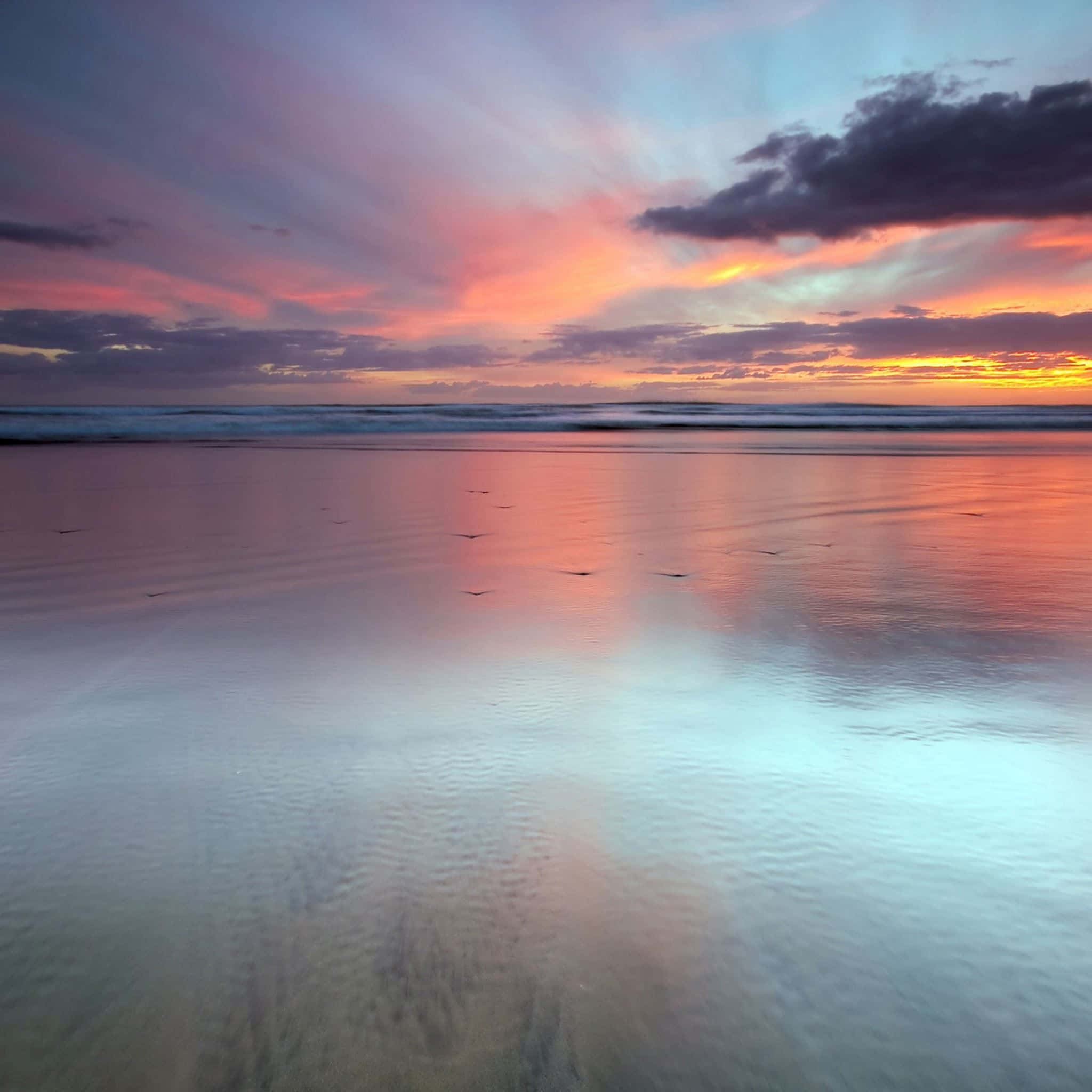 se ve un atardecer colorido desde la playa Fondos de pantalla