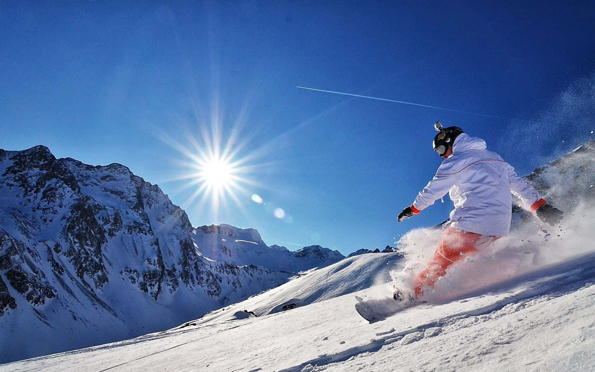 Snowboarder volando alto sobre una montaña nevada Fondos de pantalla