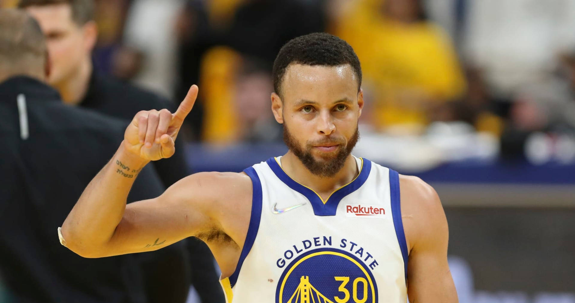 Steph Curry señalando hacia arriba con la mano derecha