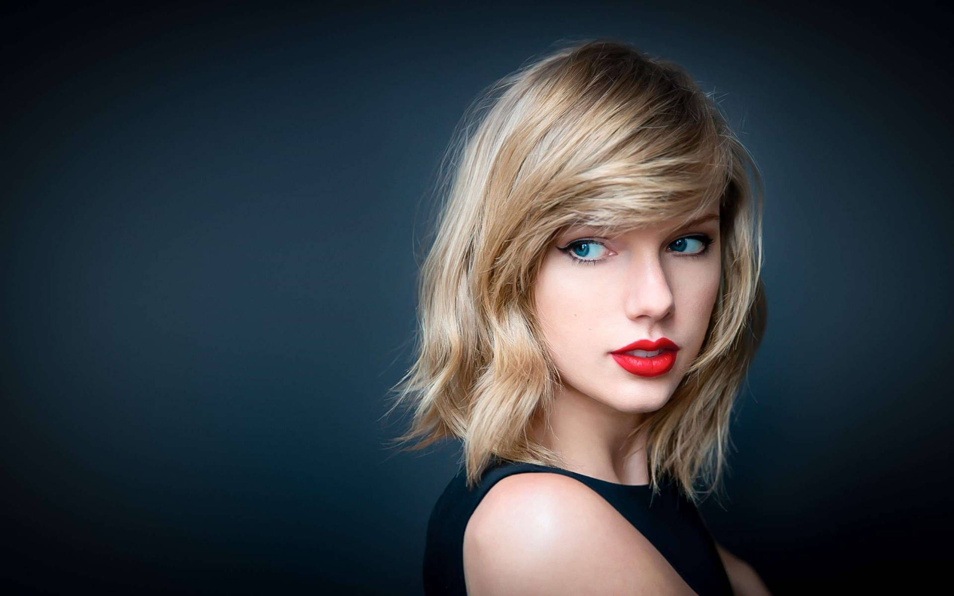 Taylor Swift luce impresionante con cabello rubio y ojos azul verdosos fondo de pantalla.